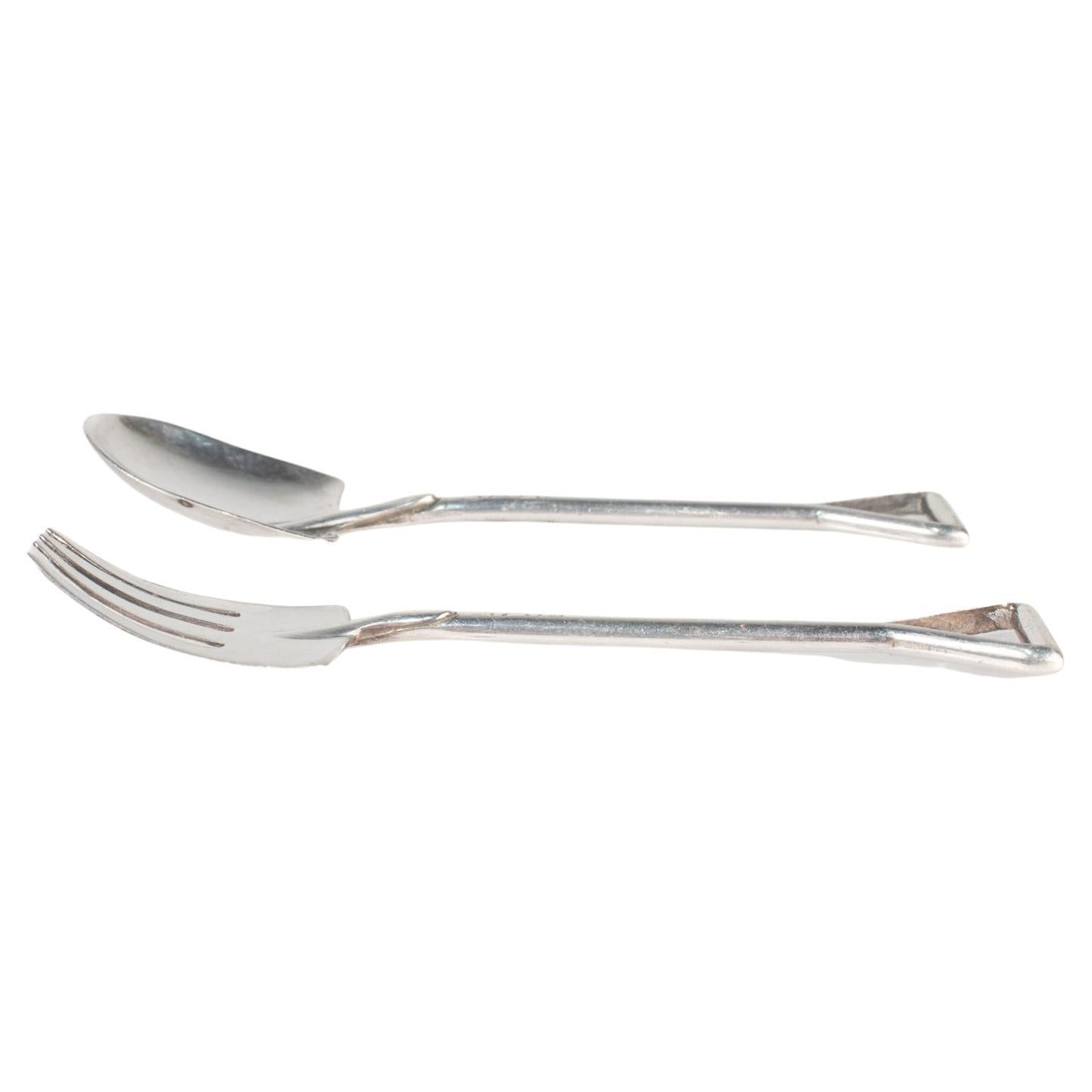 Ein vom Garten inspiriertes Gabel- und Löffelpaar

Aus Sterlingsilber.

Von Felmore. 

In Form eines Gartenspatens oder einer Schaufel und einer Gartengabel.

Einfach ein wunderbares, kleines Utensilienset, perfekt für Vorspeisen oder die