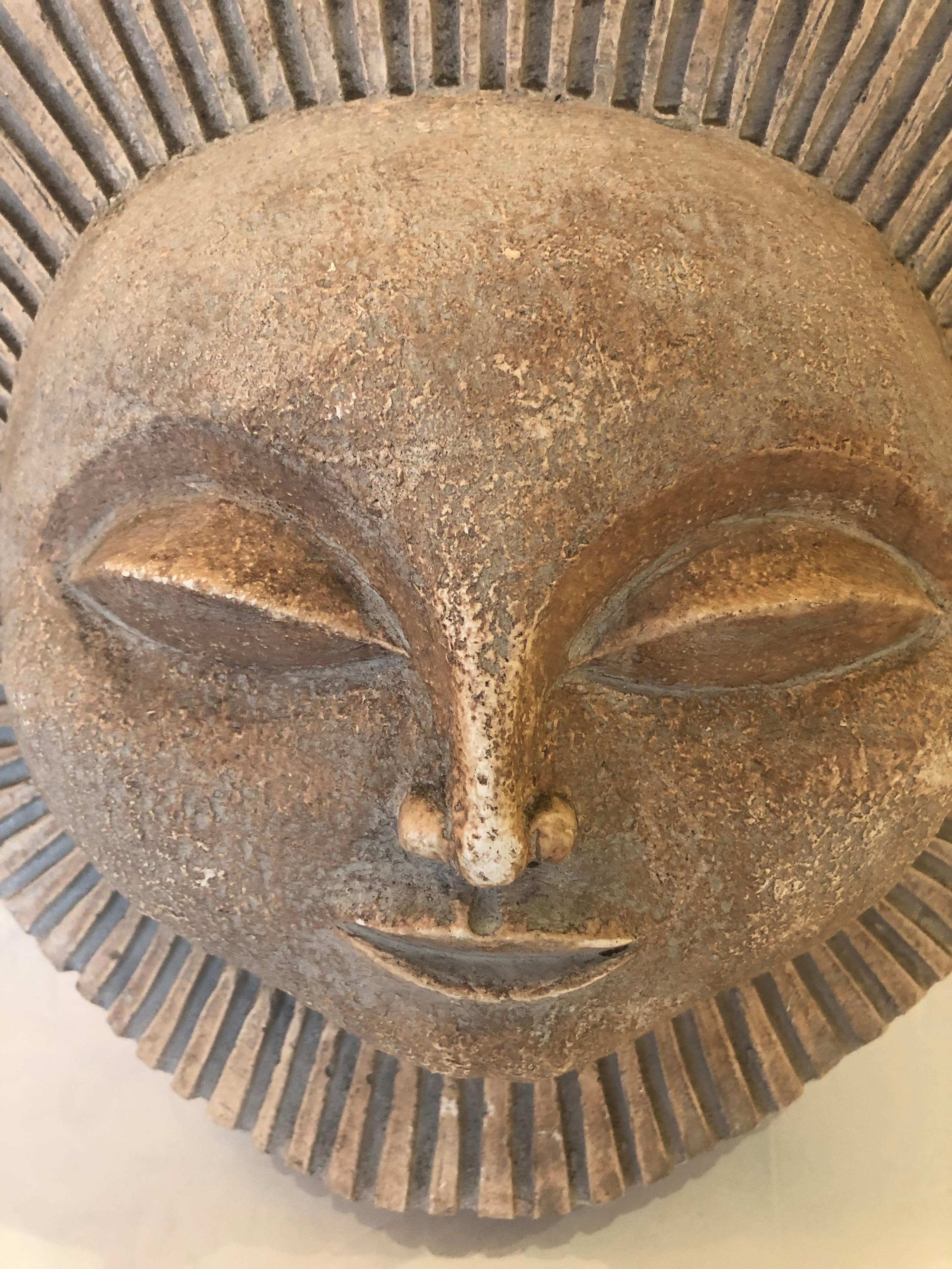 An uplifting Mid-Century Modern plaster sculpture of a stylized smiling sun.