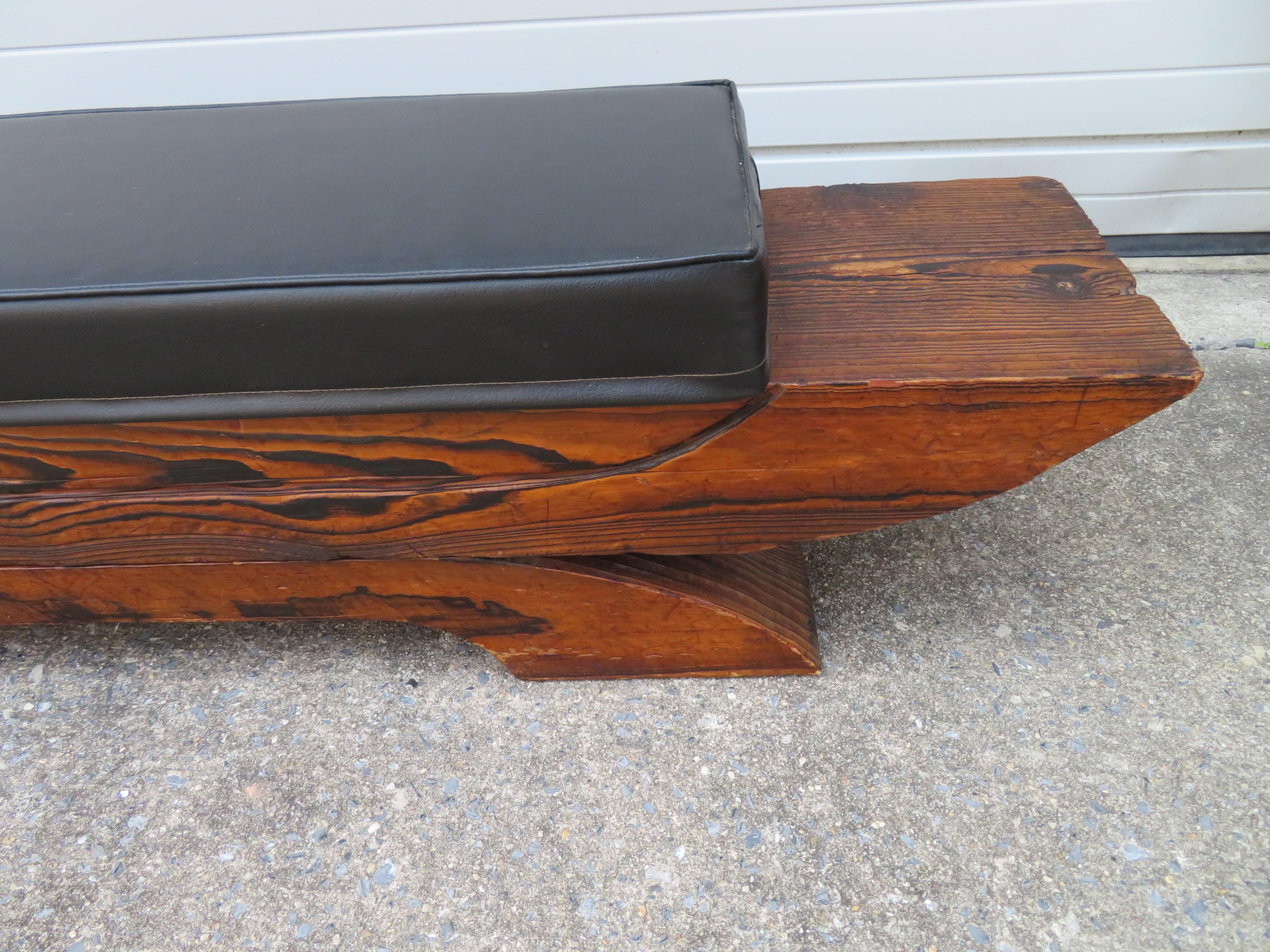 Whimsical Mid-Century Modern tiki bench made by Witco. Made of thick sculpted swamp cedar with black vinyl seating.