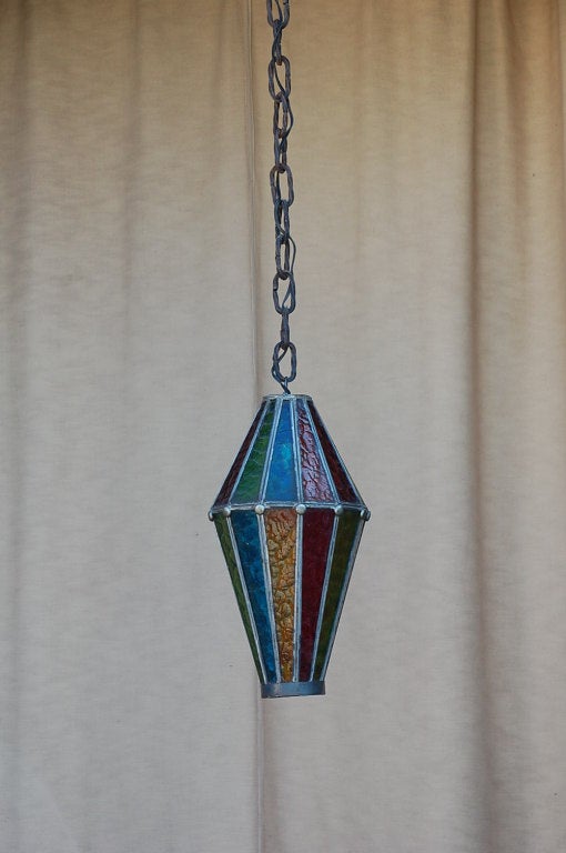 Whimsical multicolored stained glass lantern. Includes 10 ft. original wrought iron chain.
