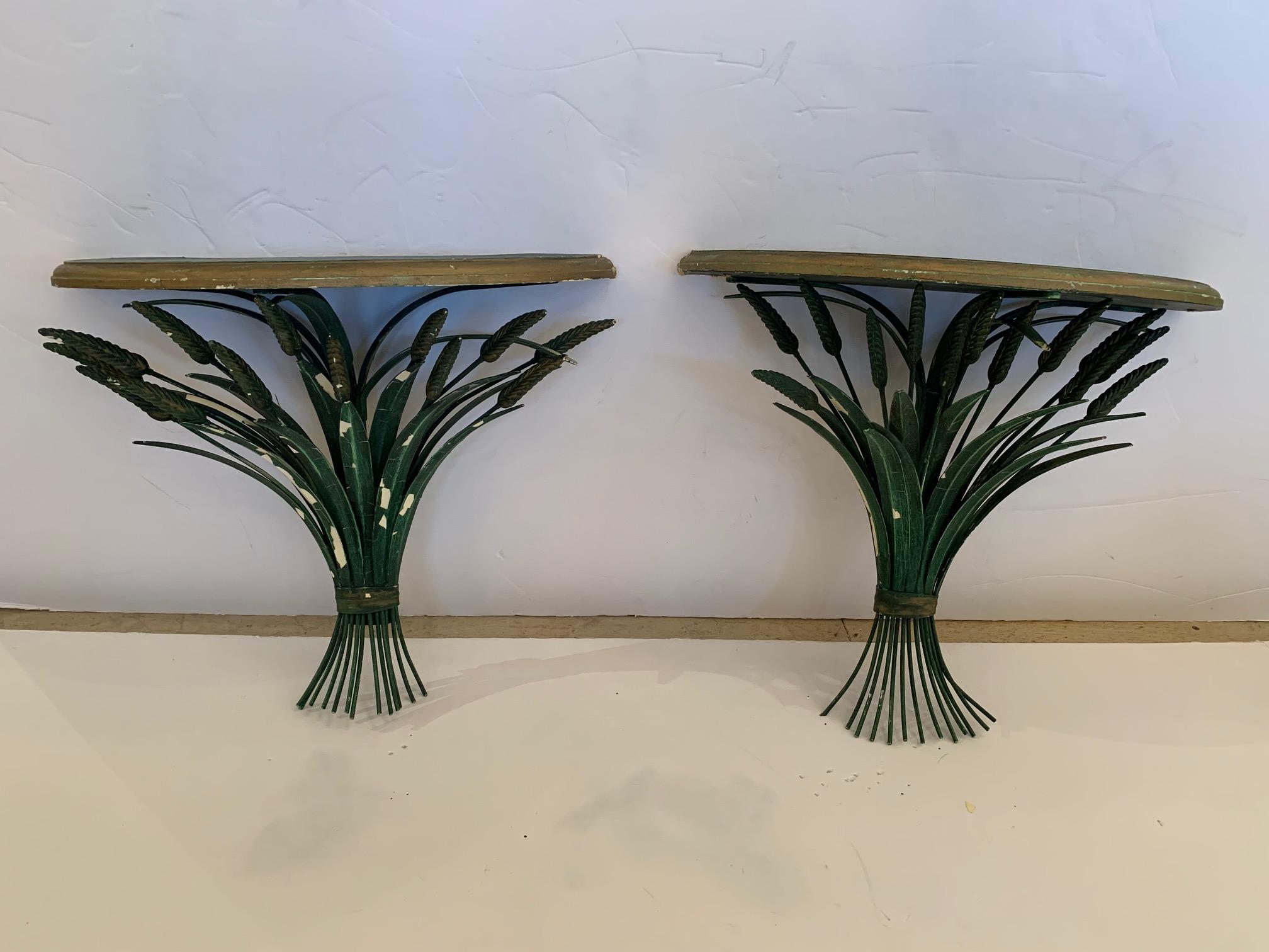 Romantic pair of painted wall brackets having green chippy wheatsheaf bases and demilune shaped painted platforms for display. Weathered patina adds to the vintage charm.