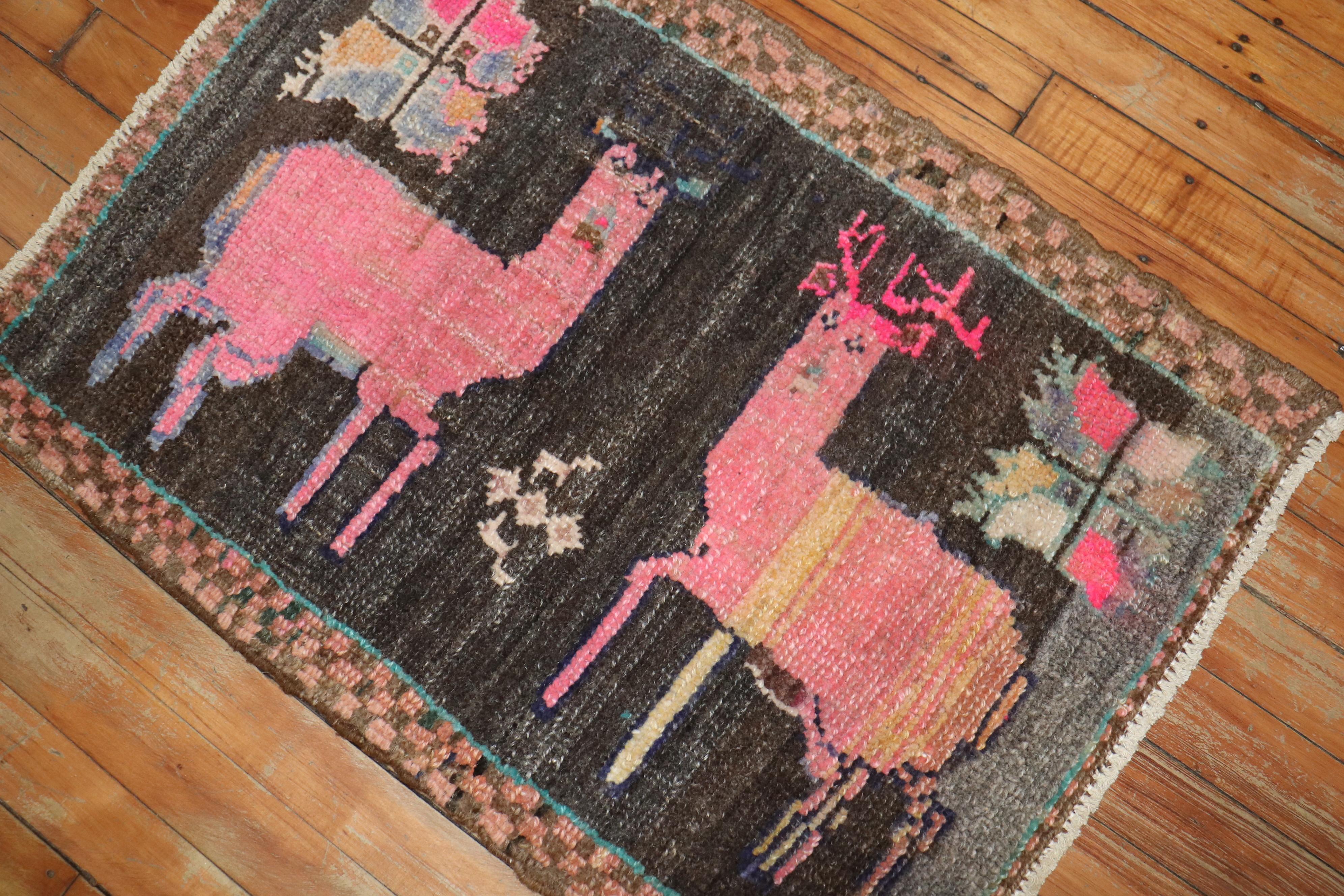 A late 20th century Turkish rug depicting 2 pink deers on a chocolate brown field. 

Measures: 1'9