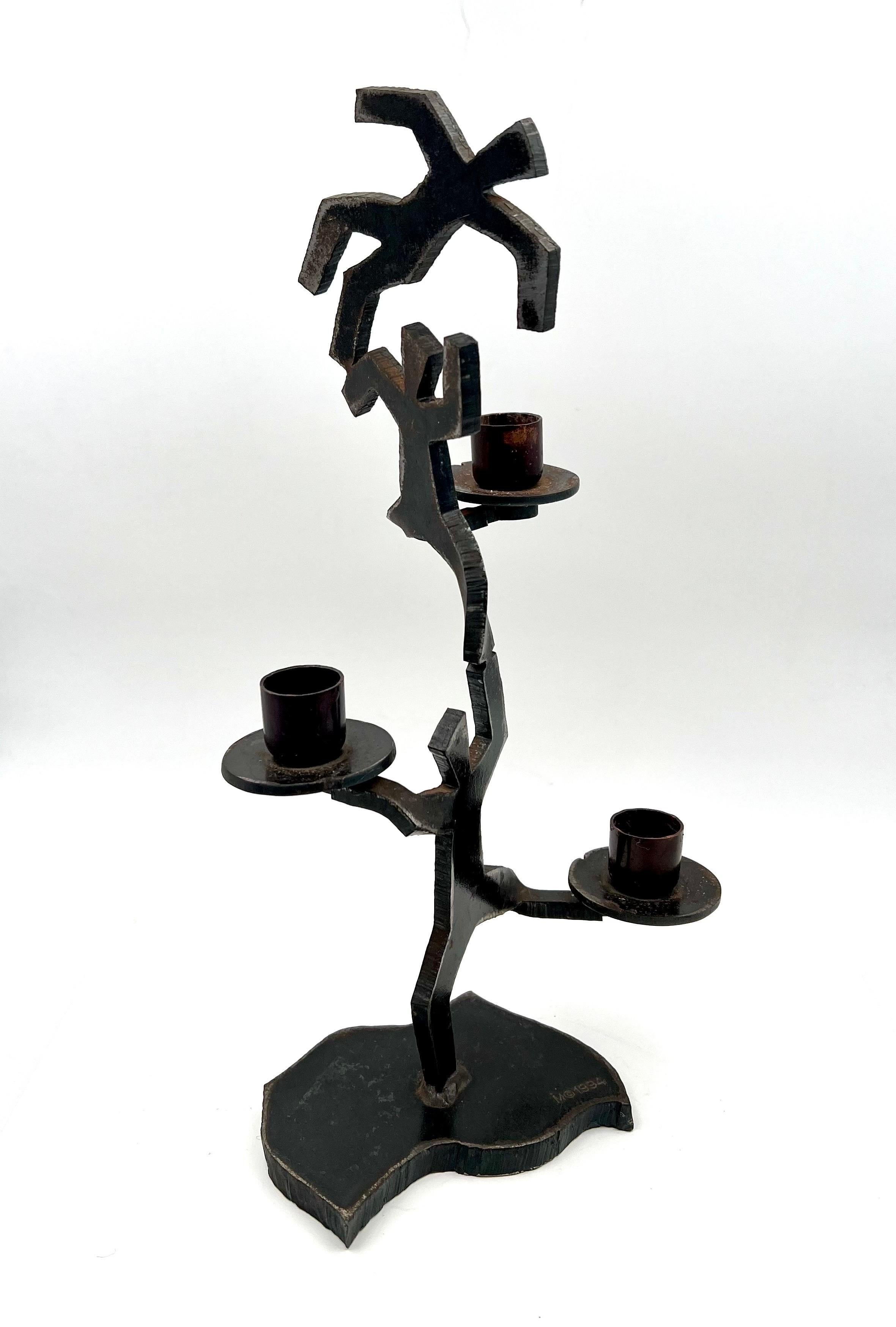 A rare candle holder Stamped M 1994, fire torch welded iron figurines after Keith Haring, each holder takes a 3/4
