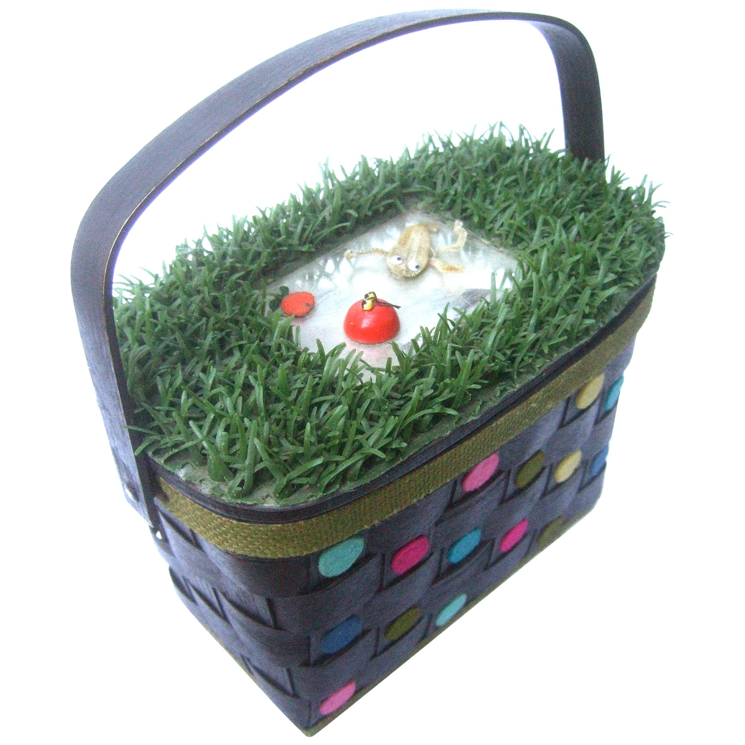 Whimsical astroturf woven wicker handmade basket purse c 1970
The quirky one of a kind retro handbag is designed with an astroturf lid cover
A mirror is placed on the center of the exterior lid cover with a pair of insects
glued onto the glass
