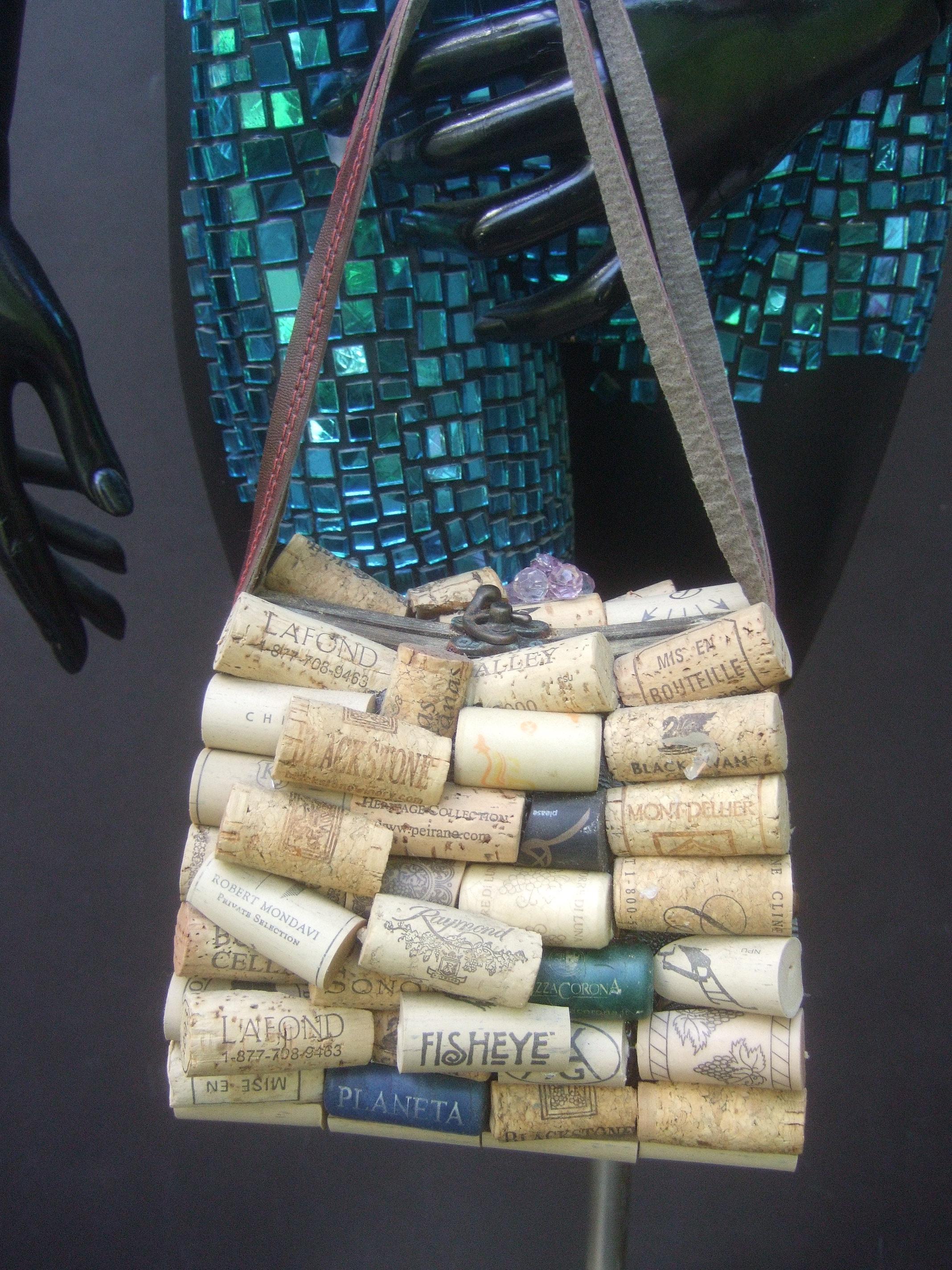 Whimsical wine cork wood box purse handbag c 1980s
The quirky wood box purse is decorated with a collection of wine bottle corks 
on both exterior front & back sides. The sides of the wood box purse are accented with a few foil
wine bottle
