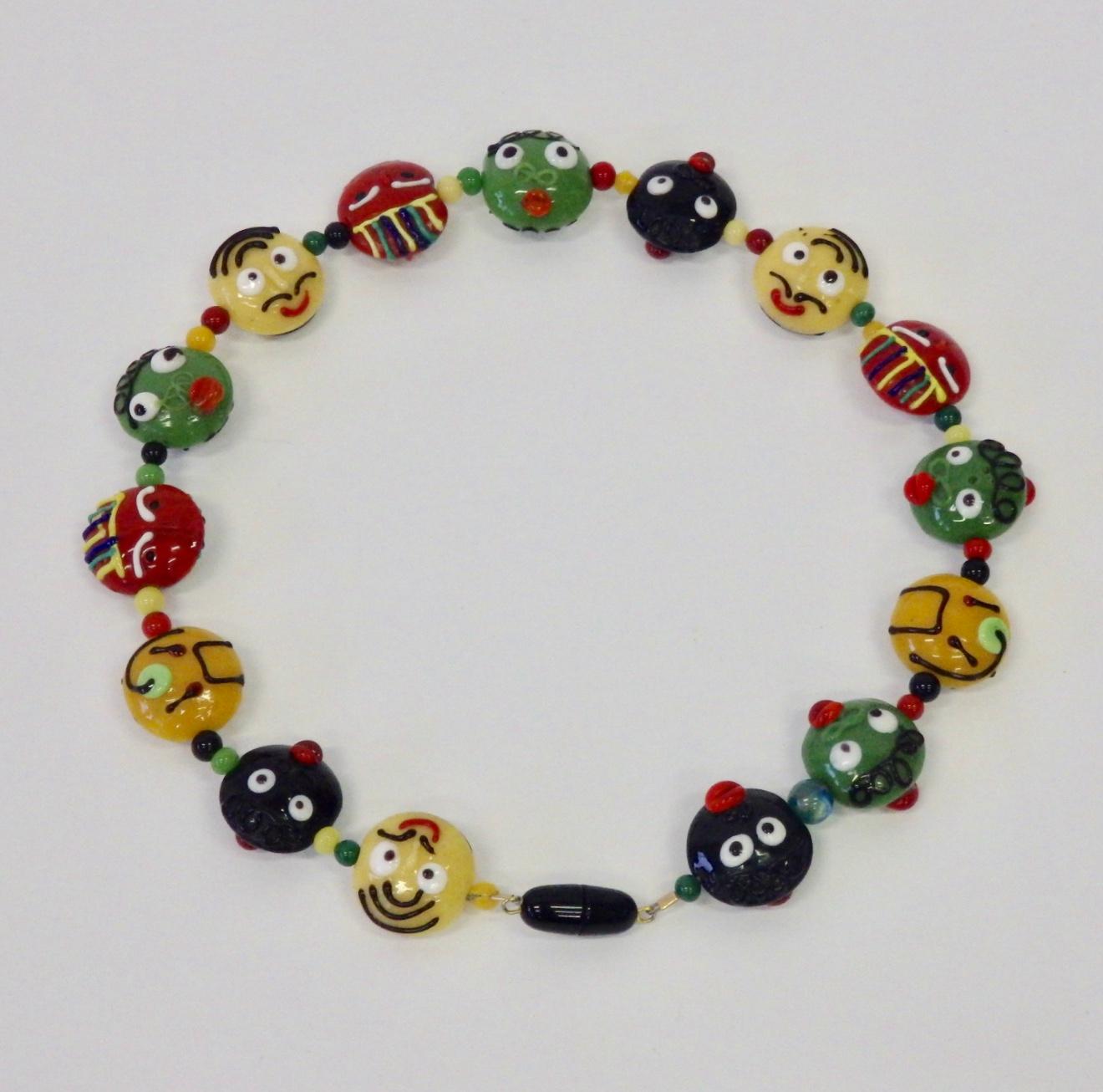 Whimsical Italian glass necklace. Depicting different oddly funny faces.