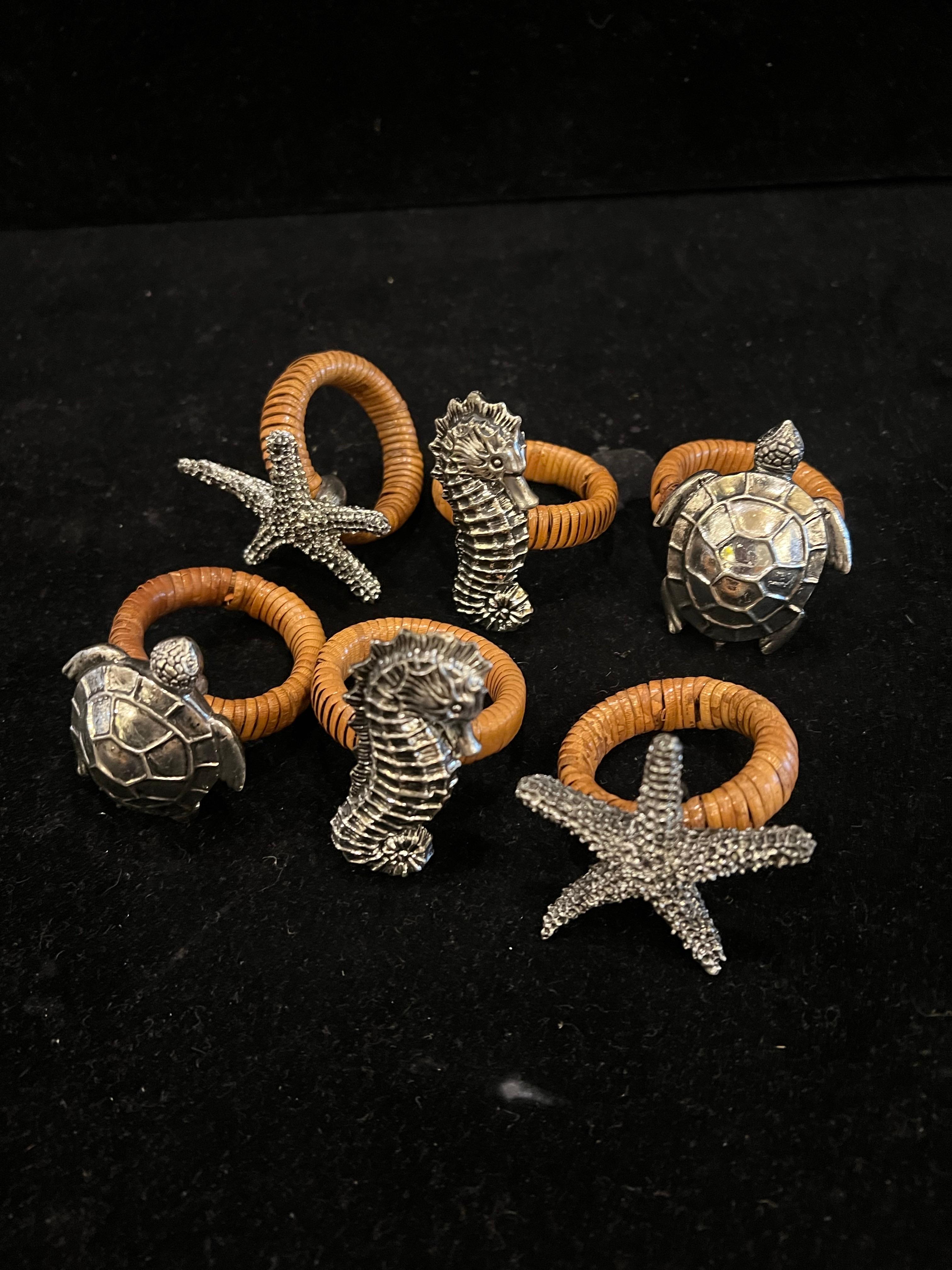Whimsical set of 6 napkin ring holders , cane wrapped ring with metal turtles , stars and sea horses chrome patinated finish nice condition.