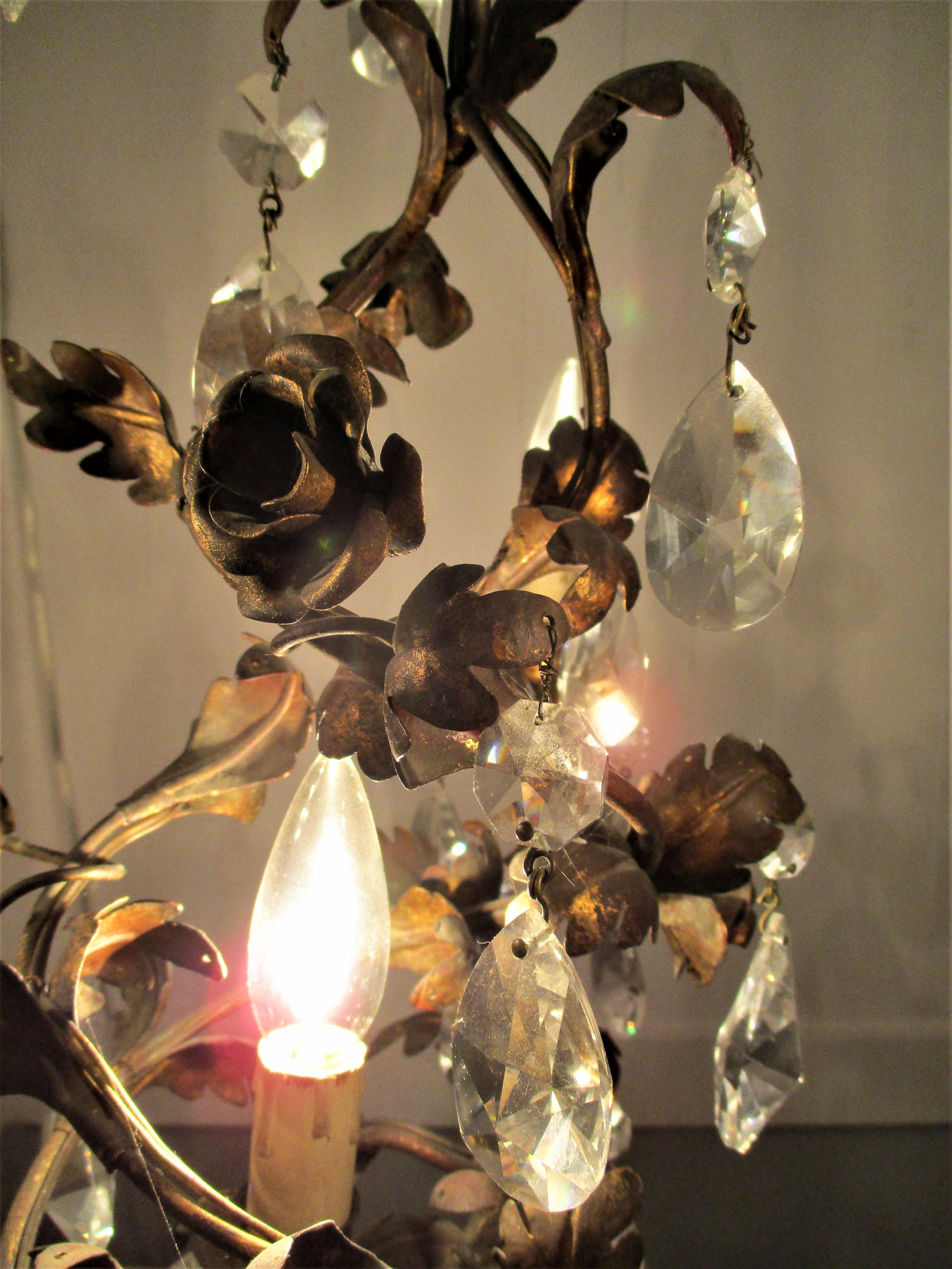 This gorgeous French 4-light, tole Strass crystal chandelier is one of a kind. The brilliance of the crystals sparkling amongst the aged gilt tole leaves and roses is magical.