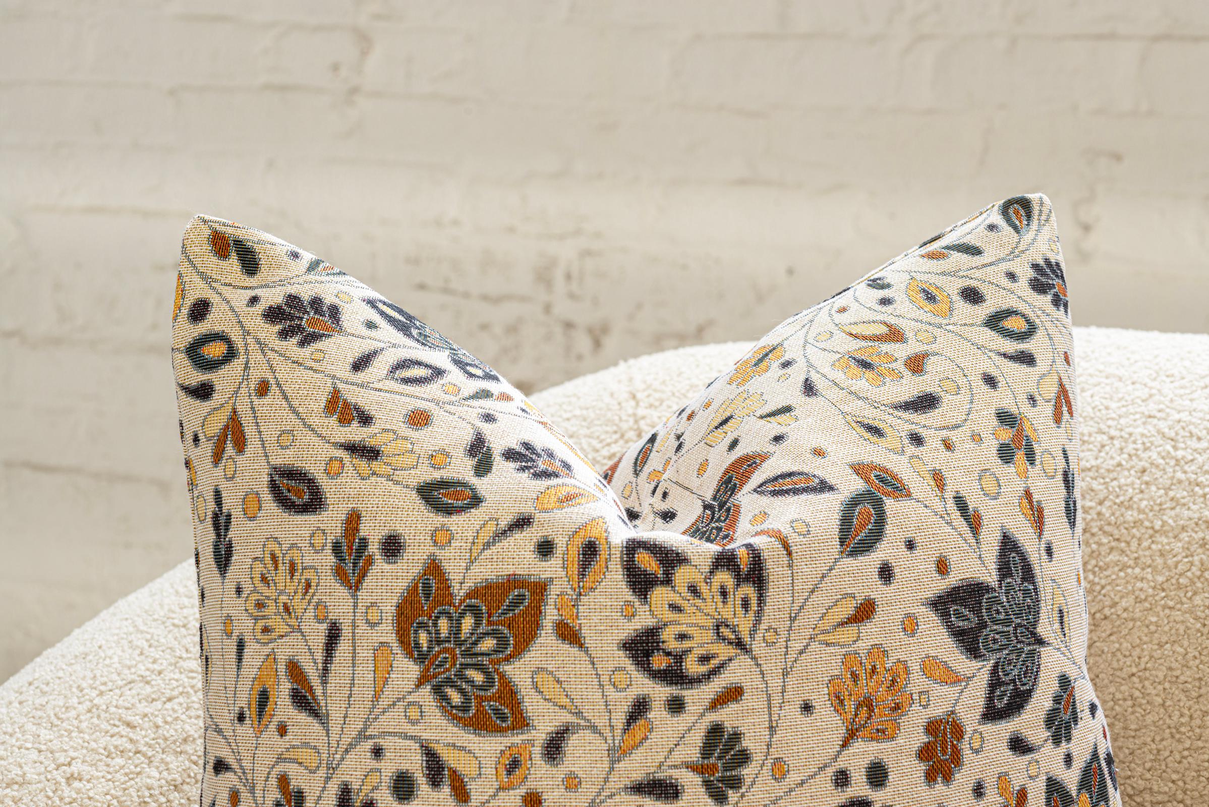Ces luxueux coussins en duvet, fabriqués à la main avec soin à Chicago, présentent un tissu unique semblable à une tapisserie qui rayonne de confort et de style. Le fond blanc du tissu sert de toile sereine, contrastant magnifiquement avec un motif