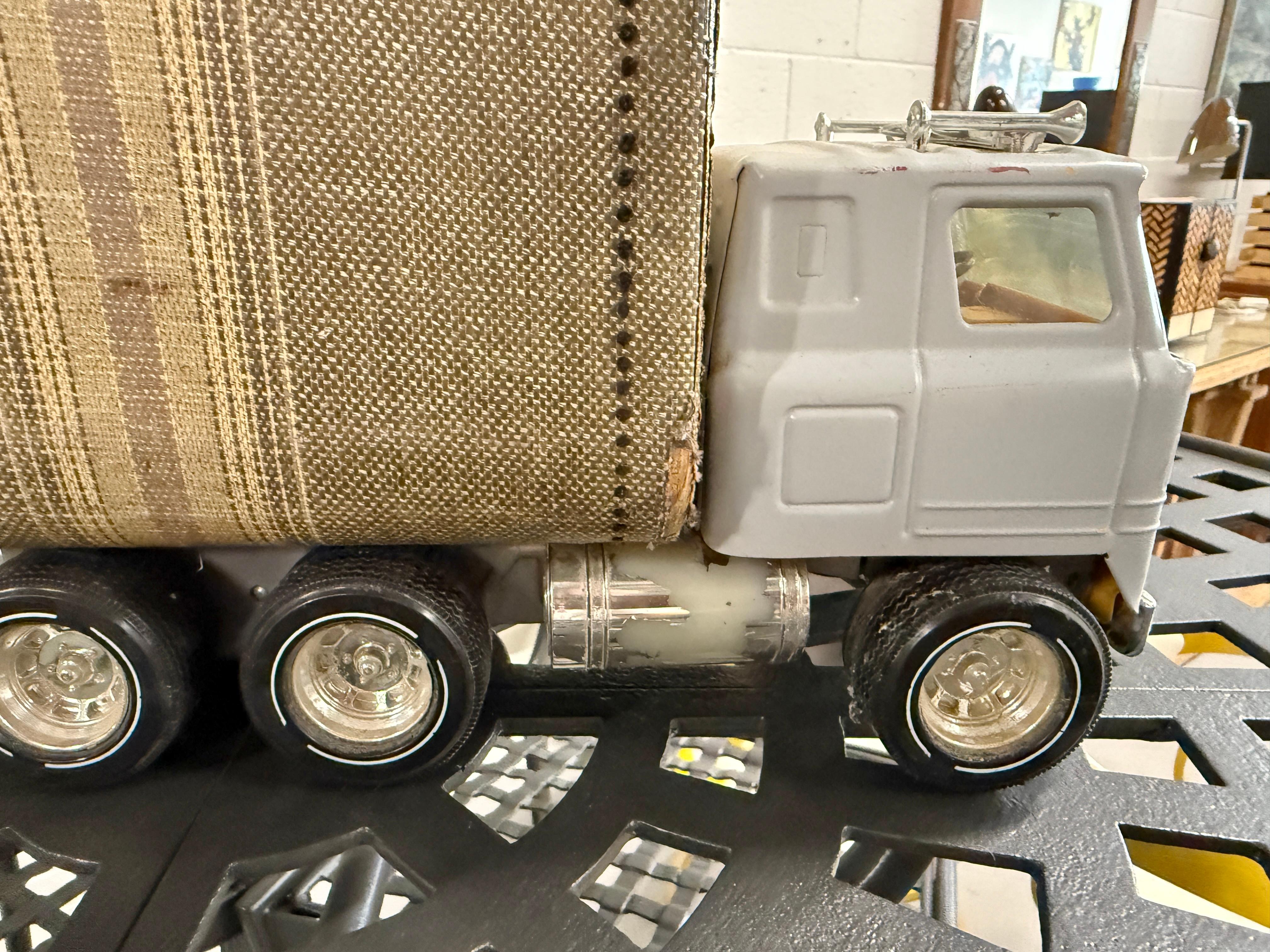 Une sculpture fantaisiste réalisée en 2005 par le célèbre artiste californien Bruce Houston. La sculpture représente une valise usée et malmenée, moulée dans une carrosserie de camion, avec des roues et une cabine de camion en modèle réduit. La