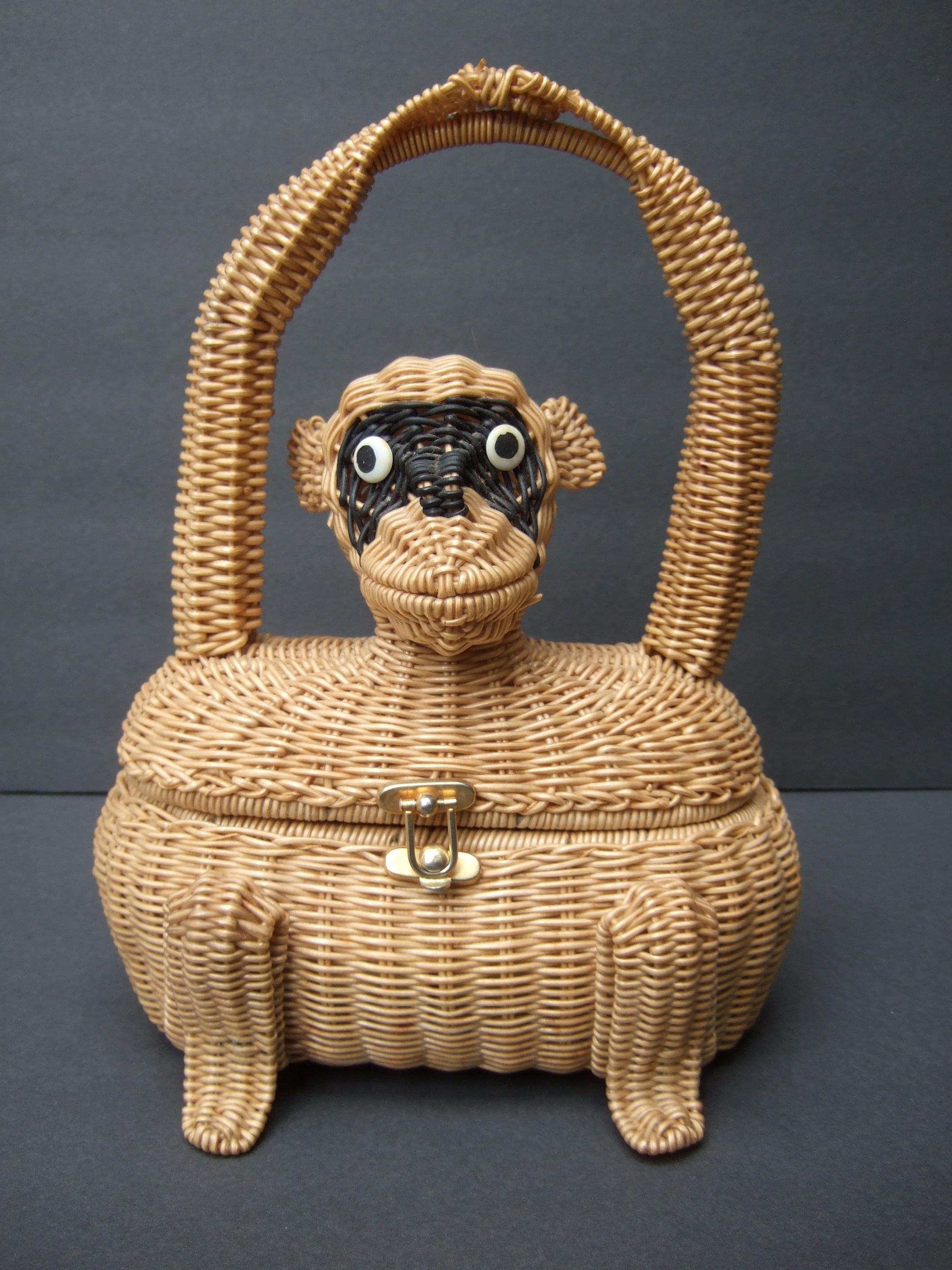 Extremely rare whimsical wicker three dimensional monkey handbag c 1960
The charming midcentury wicker handbag is designed with an endearing monkey figure
Carried with a matching wicker handle designed with the monkey's cinched arms 

The face is
