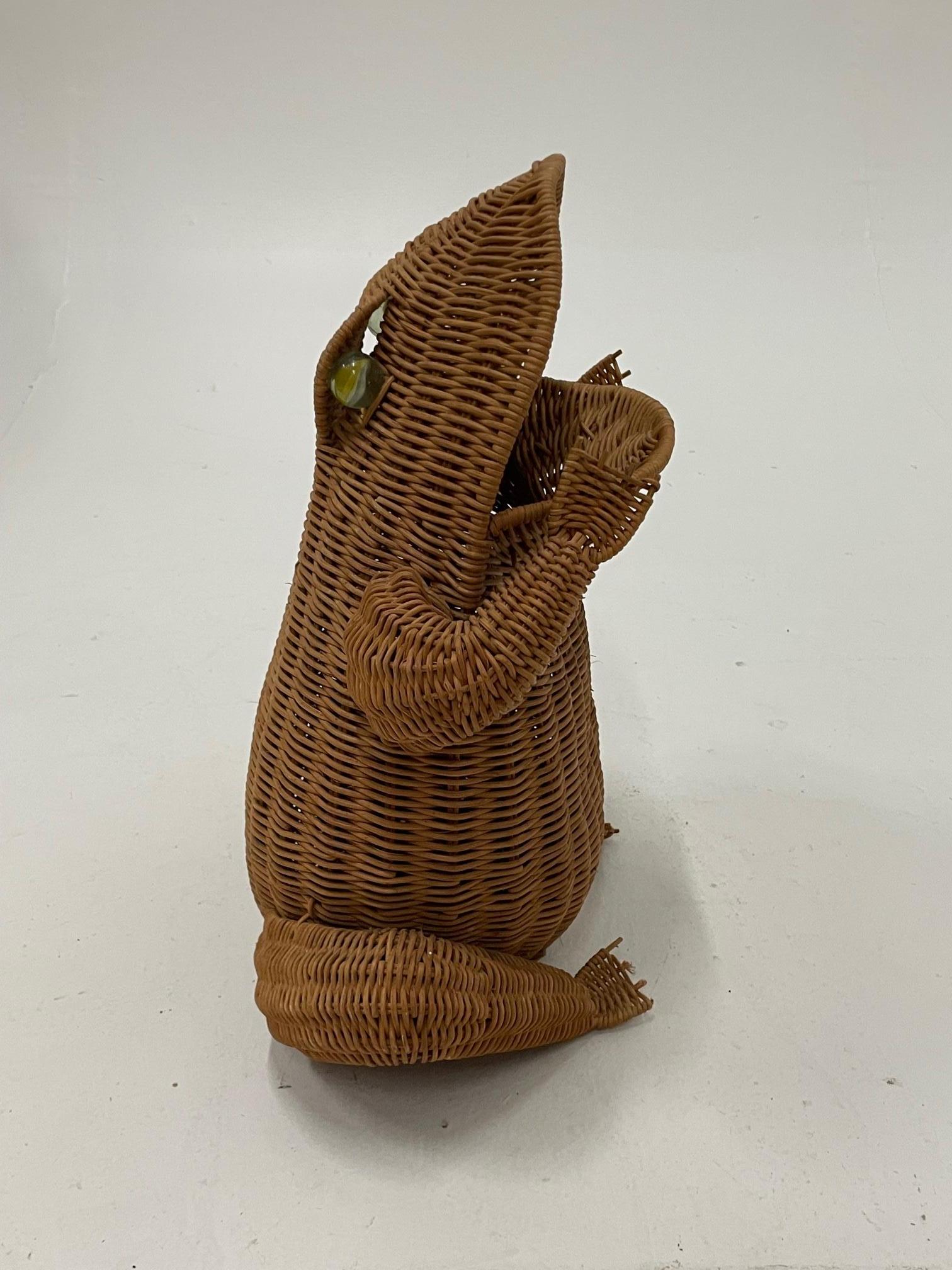 Whimsical conversation piece wicker magazine holder in the shape of a seated frog having open mouth and original glass eyes.