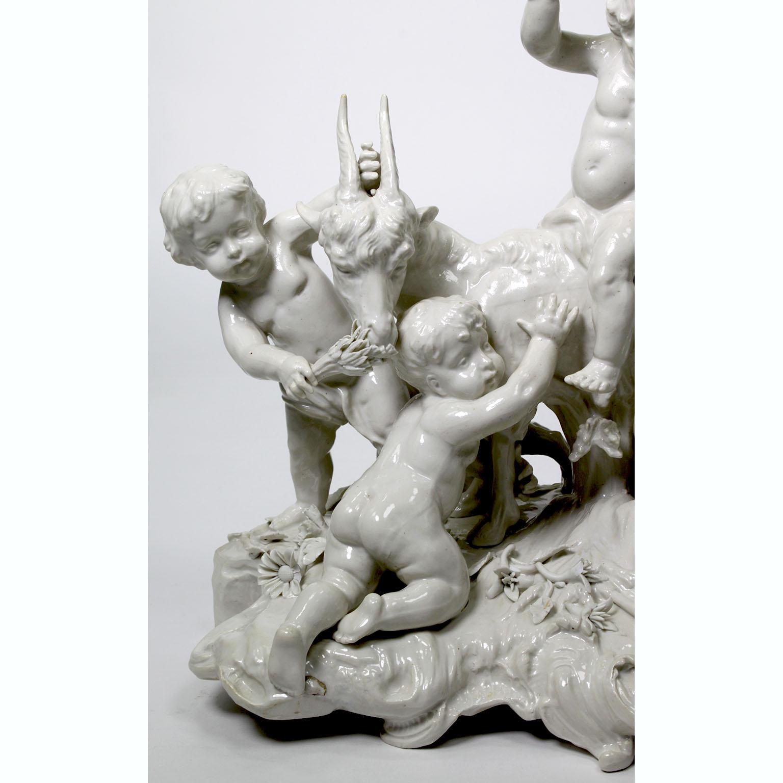 Eine charmante, skurrile, weiß glasierte Porzellangruppe aus dem 19. und 20. Jahrhundert mit vier Putten, die mit einer Ziege spielen, wahrscheinlich nach der Darstellung 