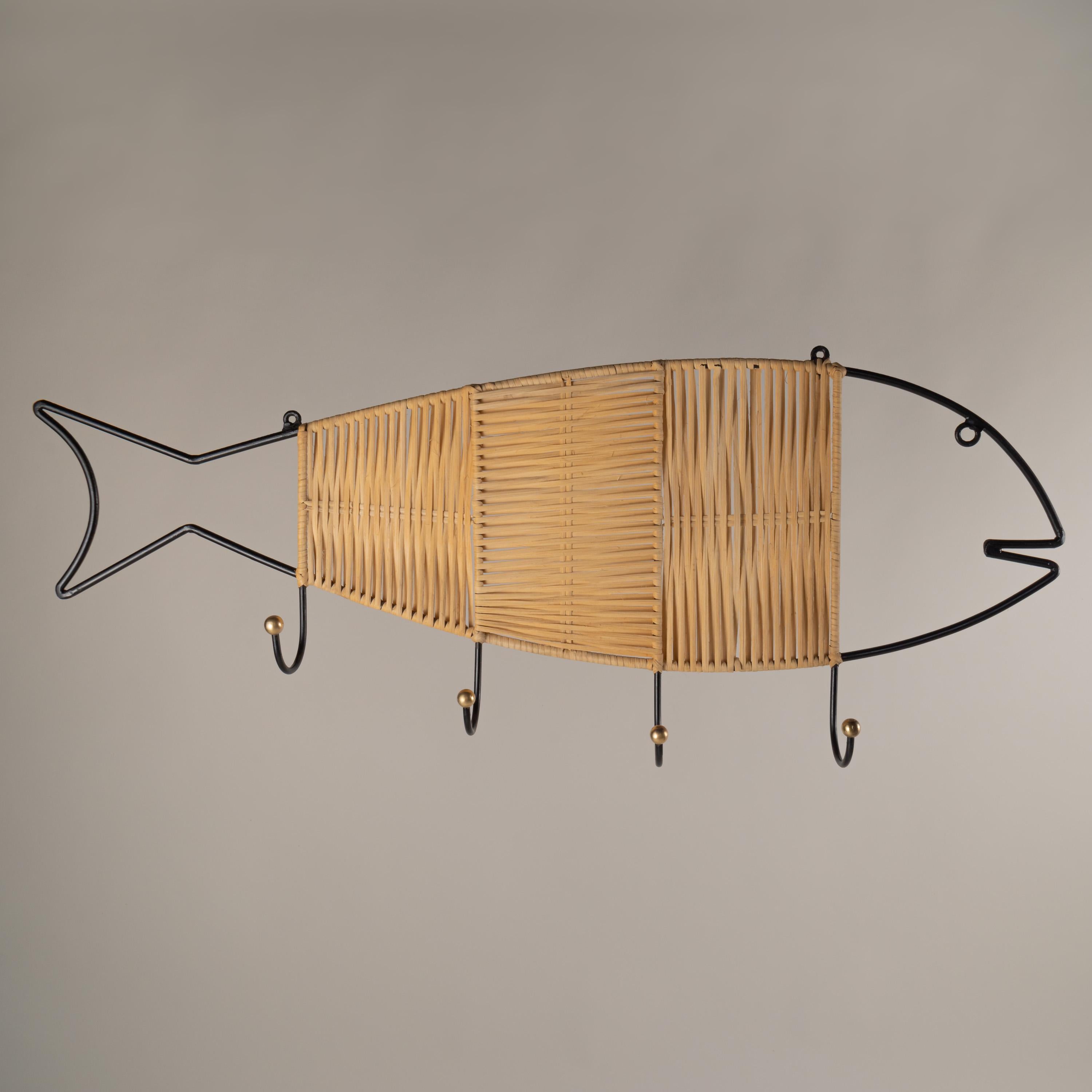 A very simple fish-shaped wall coat/hat hanger with four hooks from the 1950s. Handmade wrought iron painted in matte black made in Mexico, weaved wicker in different directions add a sense of texture to this floating whimsical fish. Each hook has a