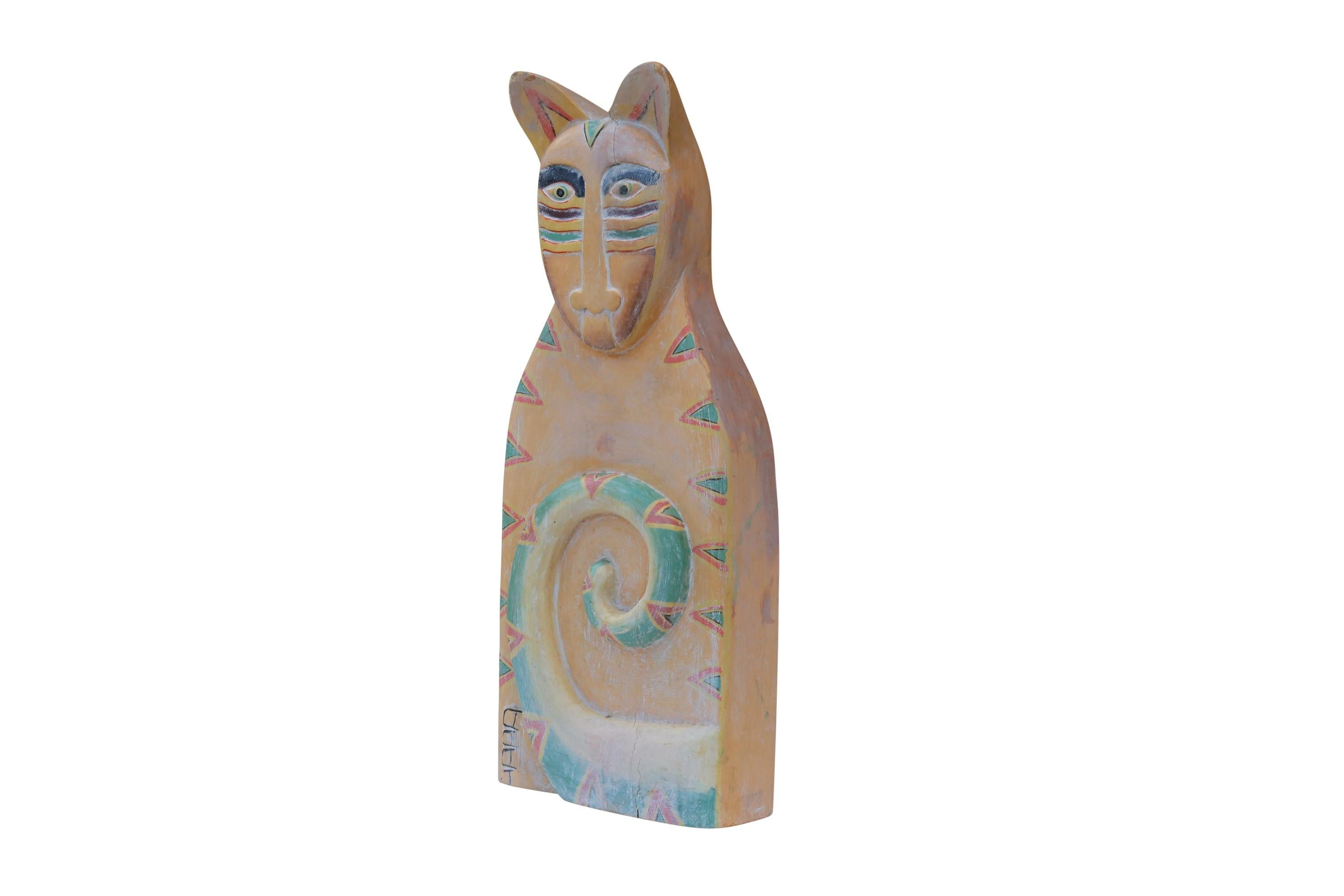 A large colorful painted wooden cat sculpture titled 'Whiskers'. Hand carved in a sitting position with a thick tail curved in front and a single showing foot. A copyright symbol and makers initials are carved in the back.