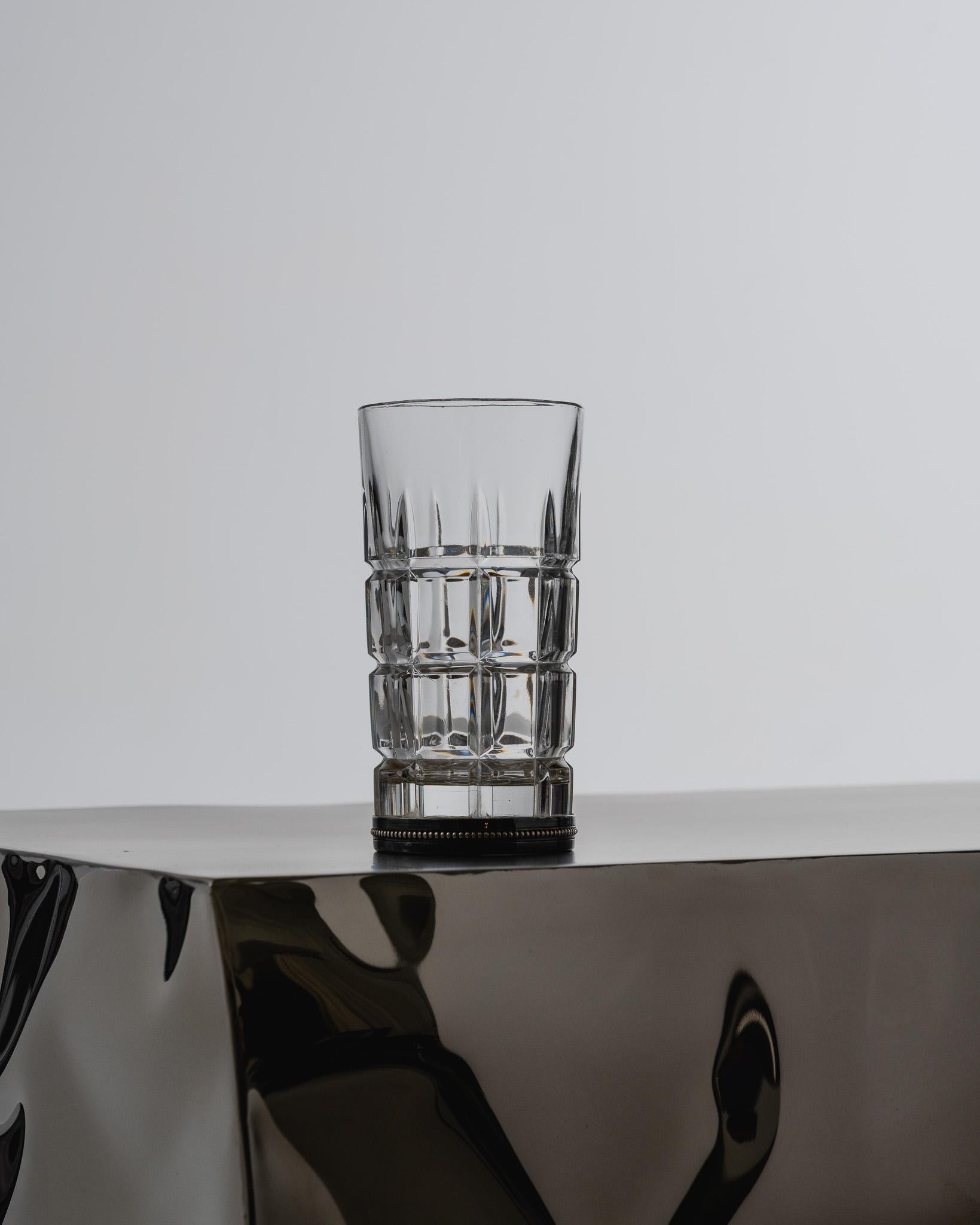Square-cut crystal whisky decanter with a set of four matching glasses, featuring a geometric pattern. Each glass rests on a silver-plated metal base, matching the metal collar on the decanter. European work from the 1960s. Very good overall