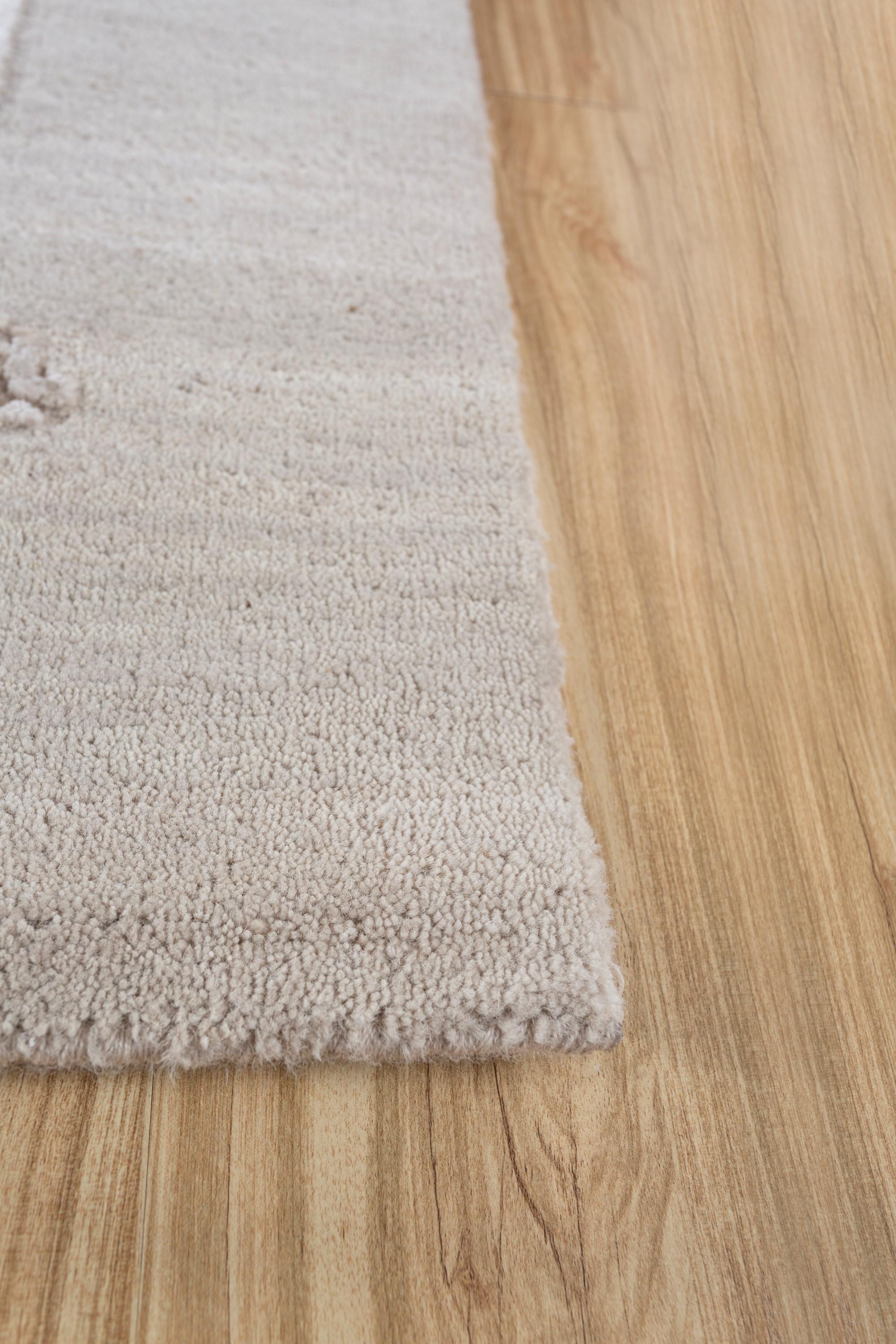 In antikes Weiß und weißen Sand getaucht, erzählt dieser Teppich eine Geschichte von zeitloser Anziehungskraft. Dieser handgeknüpfte Teppich aus luxuriöser Wolle und Bambusseide spiegelt die Inspiration der Künstlerin durch das Spiel des Lichts auf