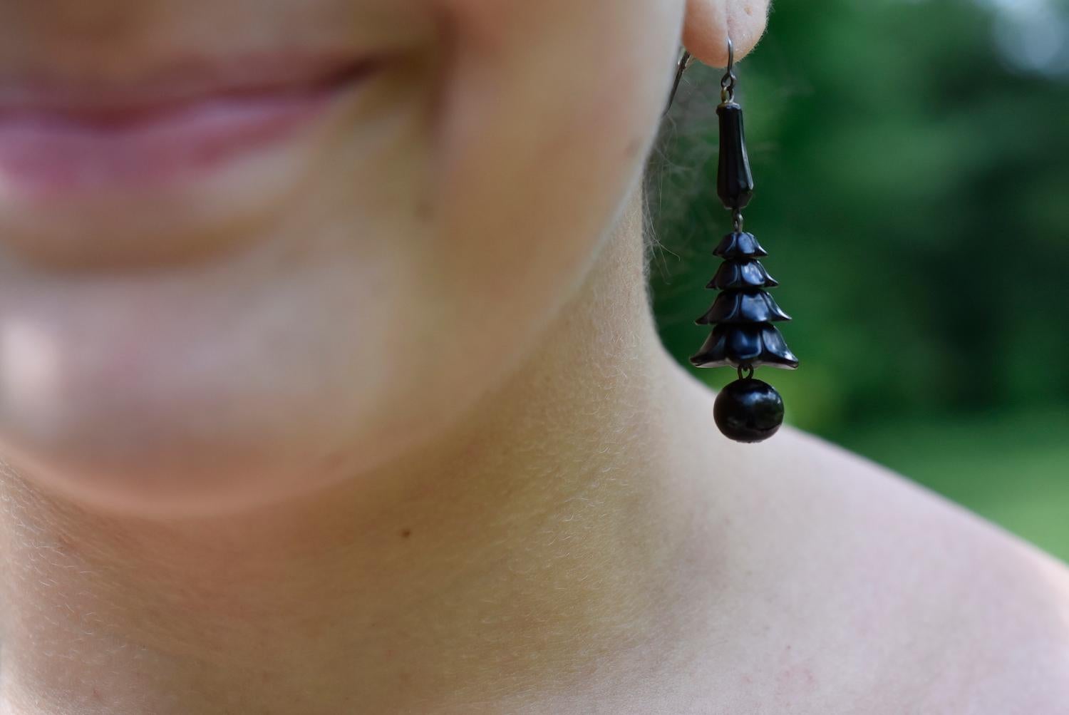 Fun and unusual earrings of Whitby jet with a jet ball hanging below carved Whitby jet florets. Whitby Jet is fossilized coal mined in Whitby, England in the 19th century and made into jet jewelry, used at the time for to create jewelry.  It was