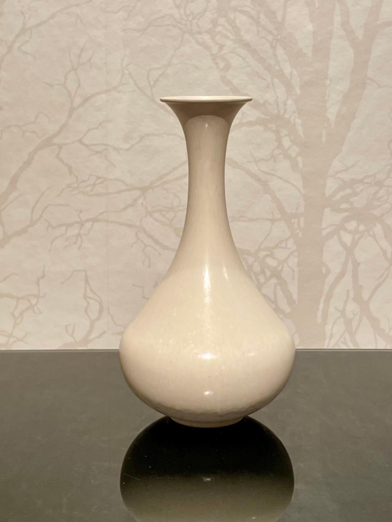 Dies ist die 1960er Jahre Eierschalen glasierte Keramikvase in weiß von Gunnar Nylund für Rörstrand. 
Sie hat eine weibliche, elegante Form und eine schlichte, weiße Eierschalenglasur mit seidenmatter Oberfläche. 
Die balustradenartige Form der Vase