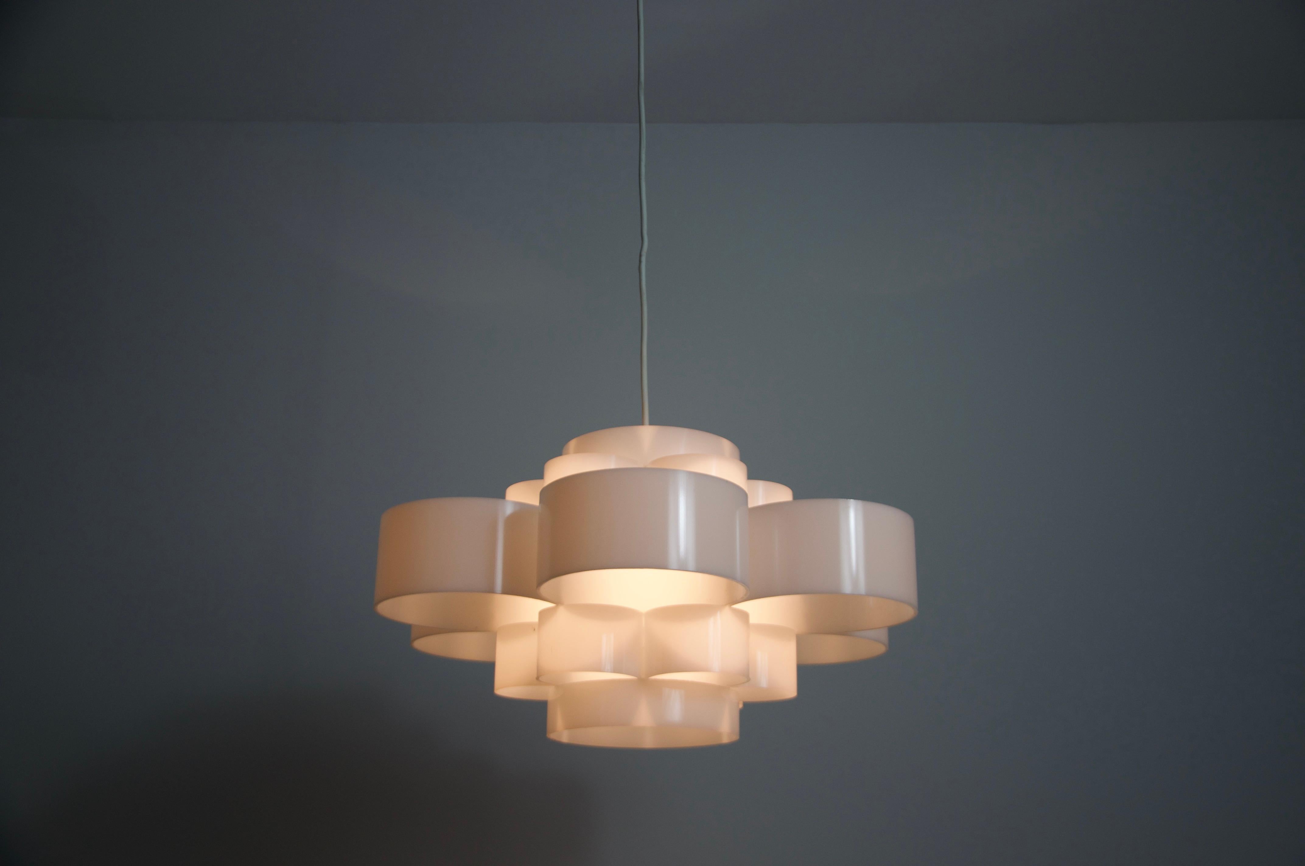 This stunning ceiling lamp from the 1970s embodies the futuristic elegance of the Space Age era. Made of high-quality white acrylic glass, it diffuses a soft, ambient glow, creating a sophisticated atmosphere in any room. Its sleek and minimalistic