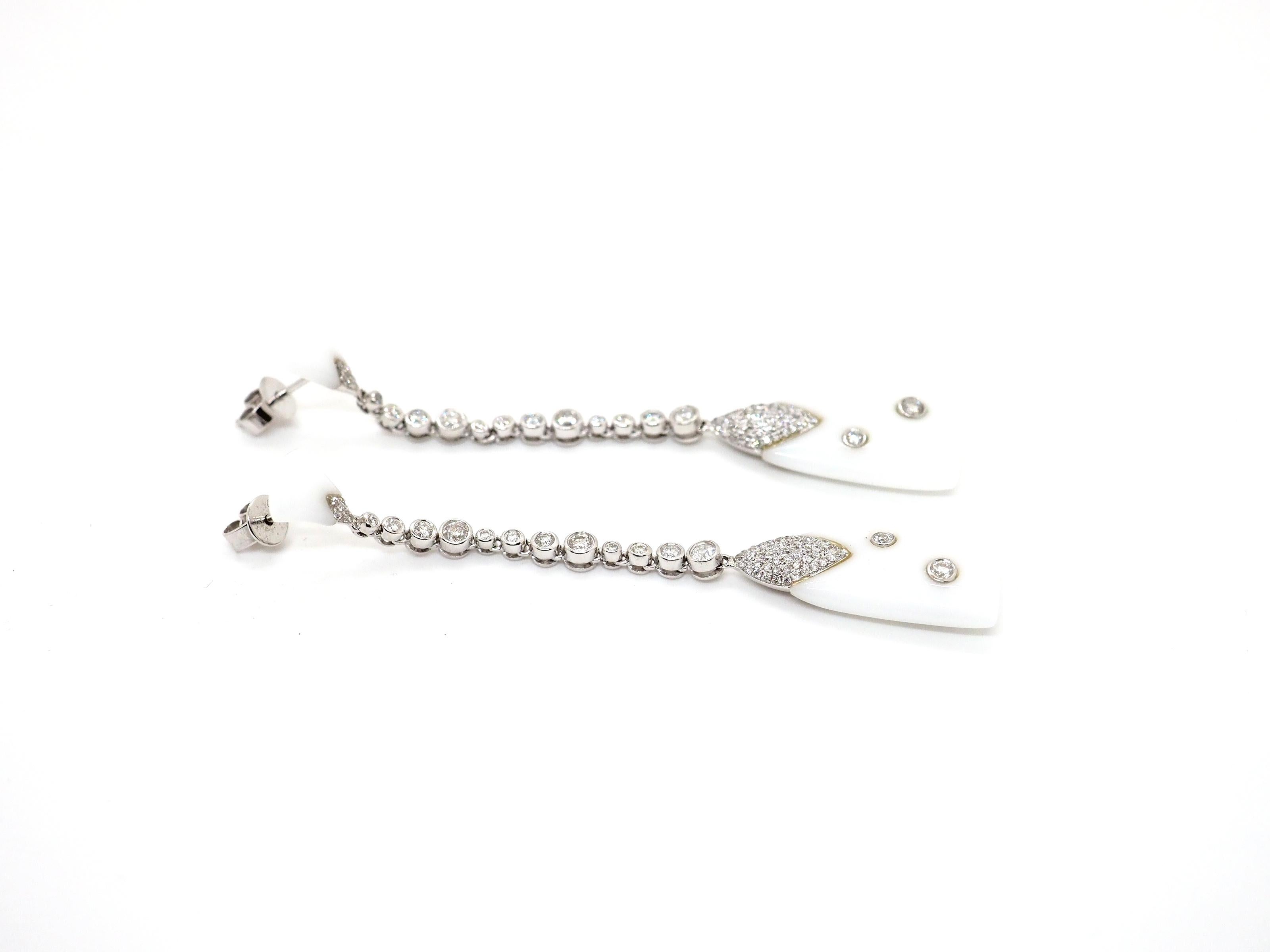 Step into the allure of vintage glamour with these exquisite drop earrings crafted in 18K white gold. Adorned with rare white agate and sparkling round diamonds of varying sizes, totaling approximately 1 carat, these earrings are a true testament to