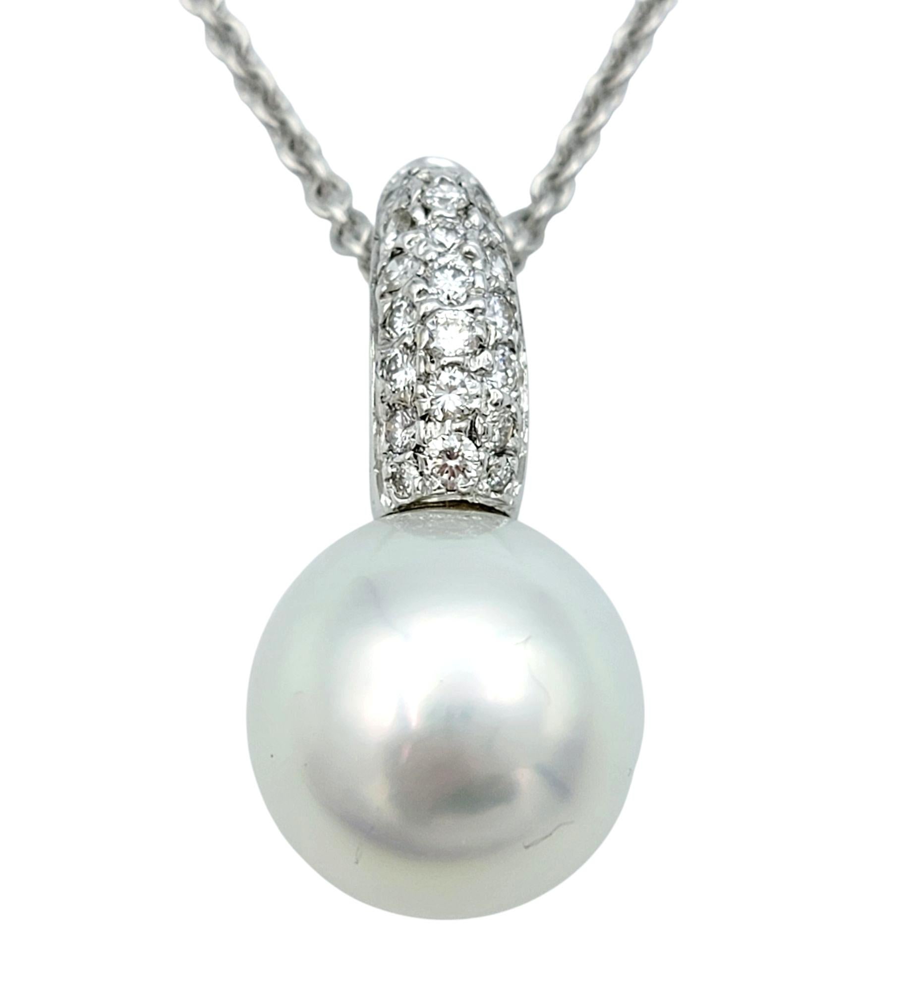 A timeless expression of sophistication, this exquisite necklace features a luminous white Akoya pearl gracefully suspended beneath a cascade of shimmering diamonds. The pearl, known for its exceptional luster and smooth surface, radiates a soft,