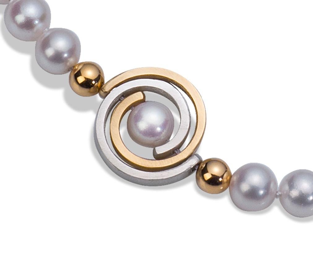 From the Orbit Collection - an 18 inch lustrous Akoya pearl necklace with an asymmetrically placed spiral, surrounded on either side by a 6mm heavy wall gold bead. The necklace is made with 7.5mm - 8mm white, round, lustrous Japanese Akoya pearls