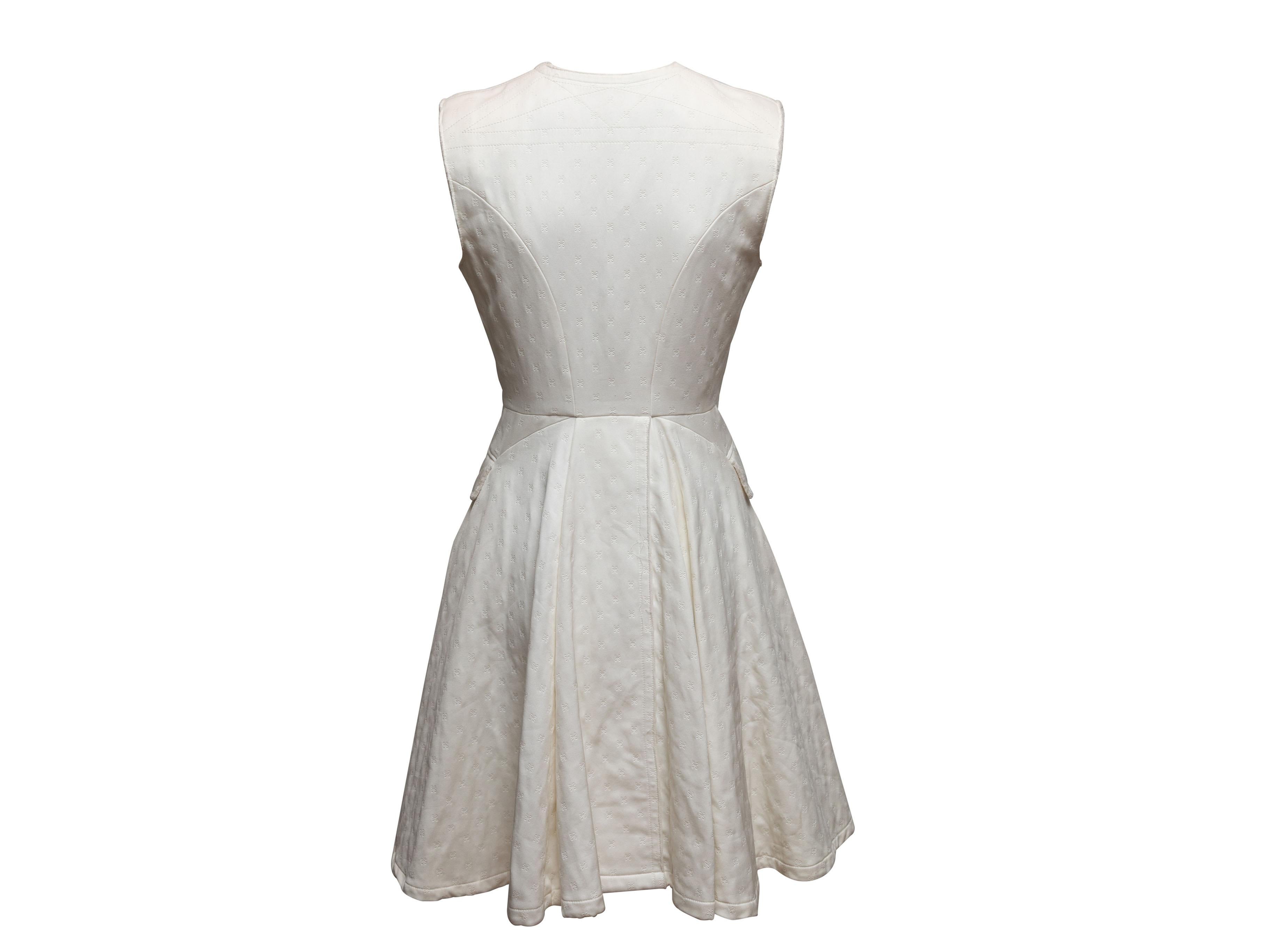 Robe sans manches à motifs de nœuds découpés, blanche, Alexander McQueen. Col ras du cou. Deux poches sur les hanches. Fermeture à crochets sur le devant. Poitrine 32