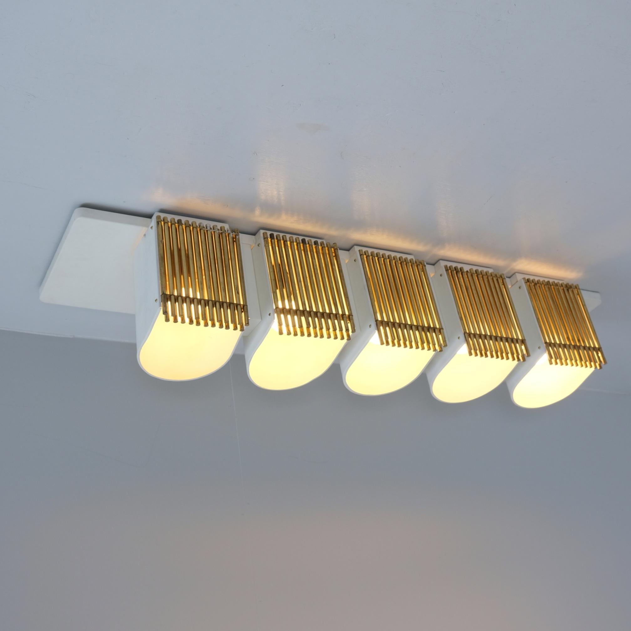 This commissioned ceiling lamp is designed by architect Alvar Aalto for the conference room of the Finnish forest industry company Enso-Gutzeit Oy in 1960s. It has a simple form yet it's quite impressive looking. The lamp is in brass and lacquered
