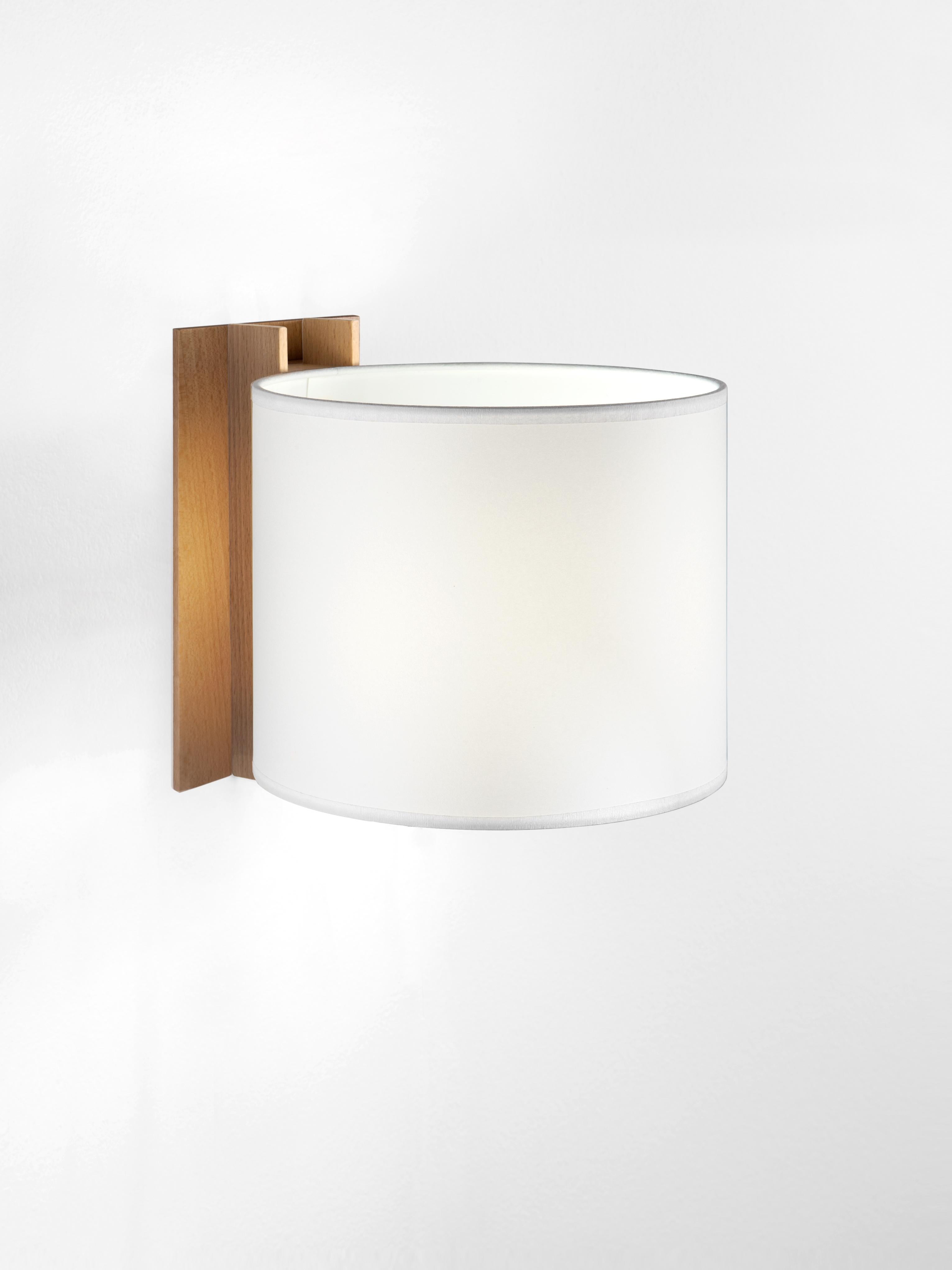 White and Beech TMM Corto wall lamp by Miguel Milá
Dimensions: D 20 x W 23 x H 20 cm
Materials: Metal, beech wood, parchment lampshade.
Direct wall.
Available in beech or walnut and in white or beige lampshade.
Available with plug or direct