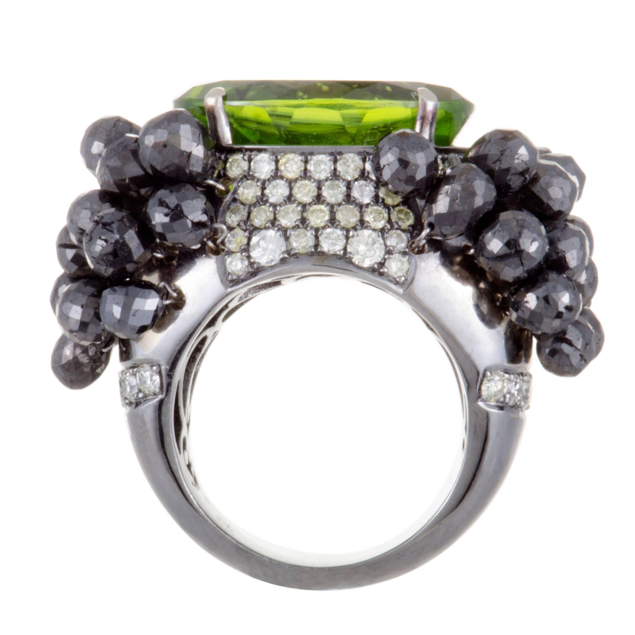 The compellingly offbeat appeal of black rhodium-plated 18K white gold is exquisitely complemented in this superb ring by an attractive blend of eye-catching gemstones. The central place is taken by a striking peridot that weighs 18.95 carats, and
