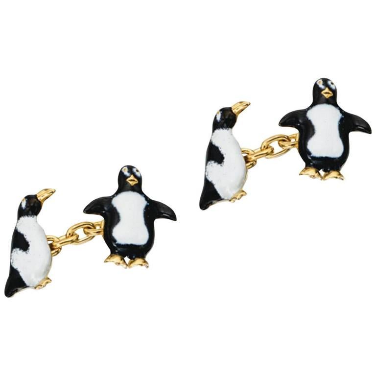 Pair of cufflinks designed as penguins on the front and the side, applied with black and white enamels. 

Gold chain link connections.   

Mounted in 18Kt yellow gold
