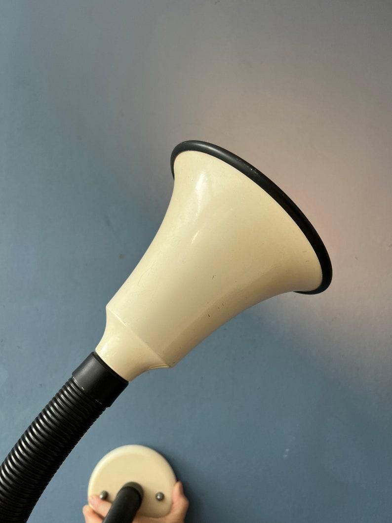Applique flexible de l'ère spatiale avec bras tubulaire noir réglable et abat-jour en métal blanc. Le store peut être tourné dans n'importe quelle direction. La lampe nécessite une ampoule E27 (standard) et dispose actuellement d'une prise de