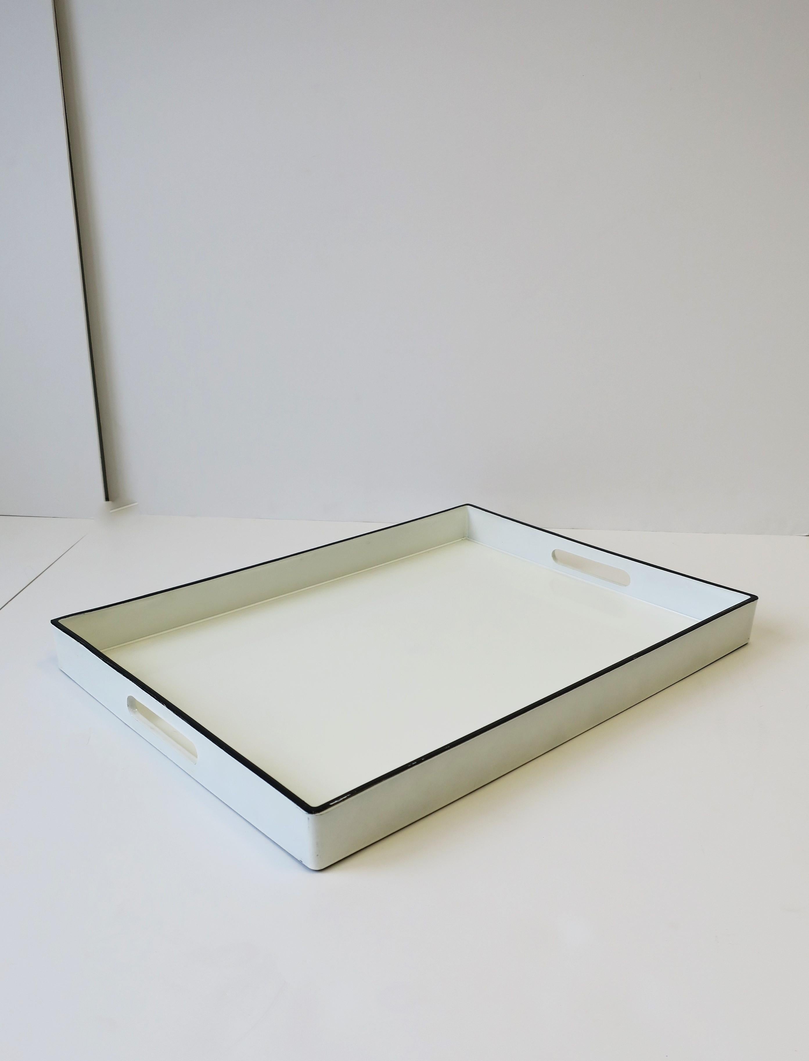 A great Modern or Minimalist style white and black lacquer rectangular serving tray with cut-out handles. Tray is white lacquer with black edge/trim. A great piece or any bar, bar cart, entertaining area or to hold books, etc. on a table. Many uses.