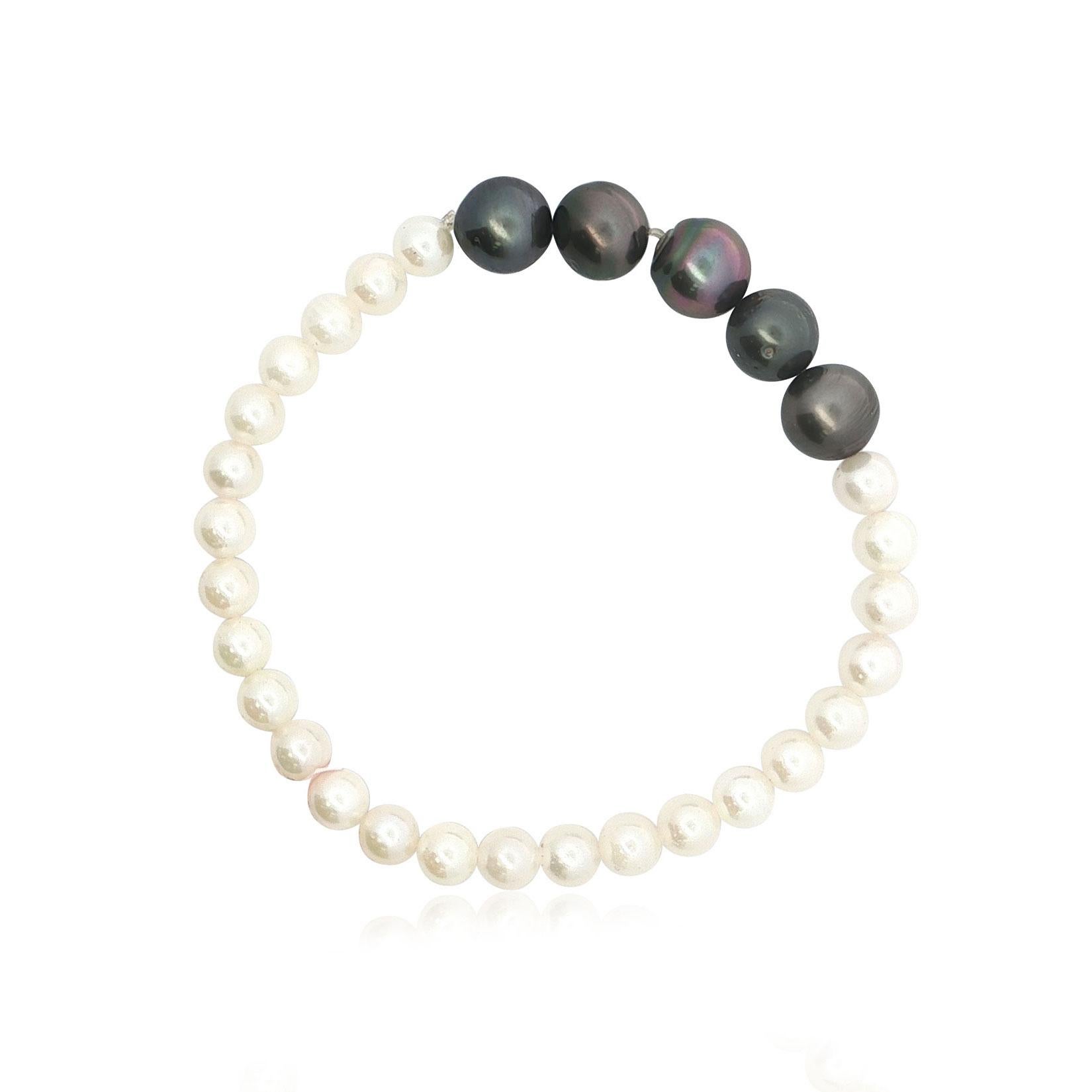 Questo esclusivo bracciale di perle unisce un'eleganza senza tempo a un tocco audace e moderno. Con perle bianco crema accentuate da cinque lucenti perle nere al centro, il sorprendente contrasto di colori e dimensioni crea un design raffinato e