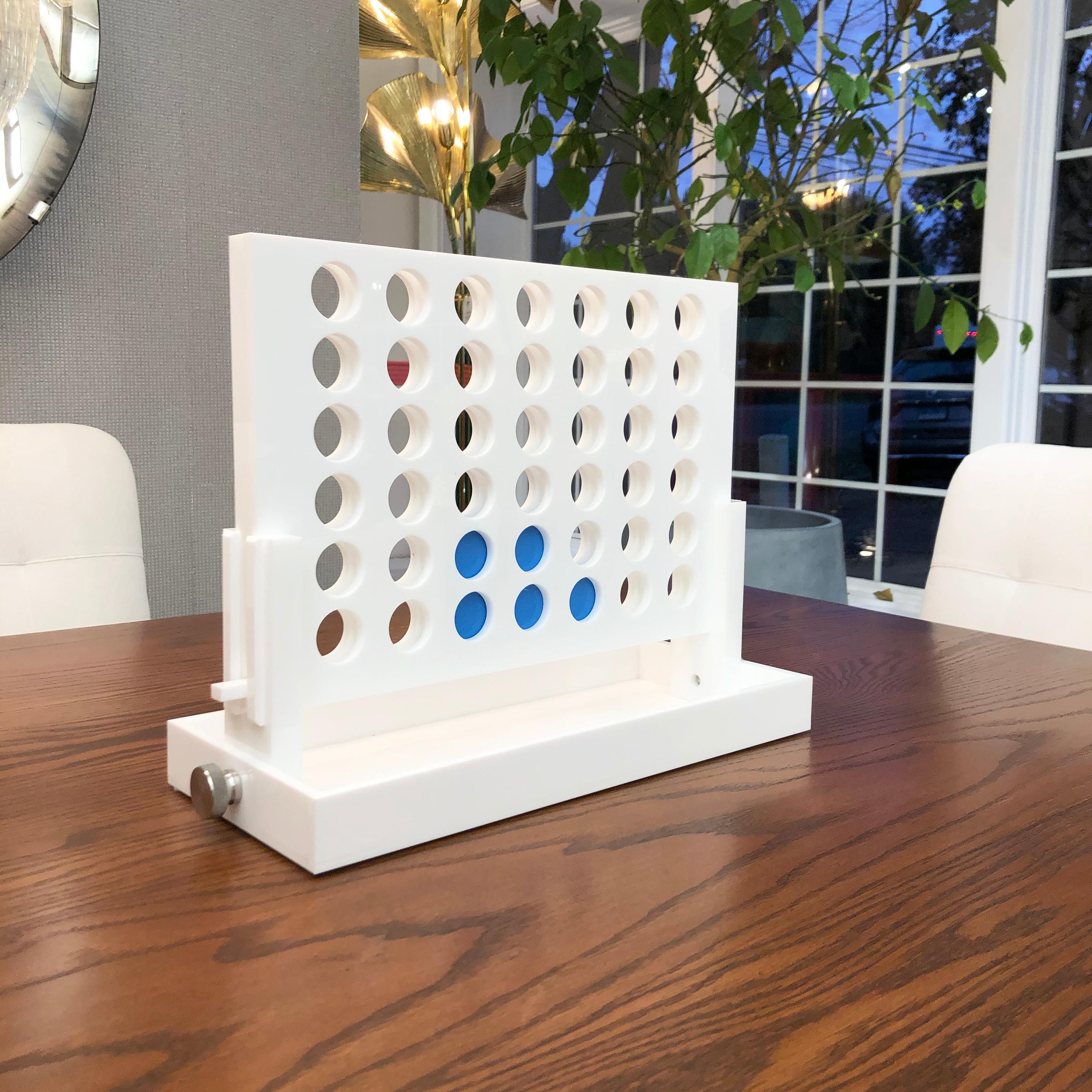 The Classic game of Connect Four is reimagined. Crafted out of acrylic and lacquered white, the game features dark and light blue chips that are pleasing to the eye; allowing this piece to be kept out year round as decor. 

Measurements

13” H x