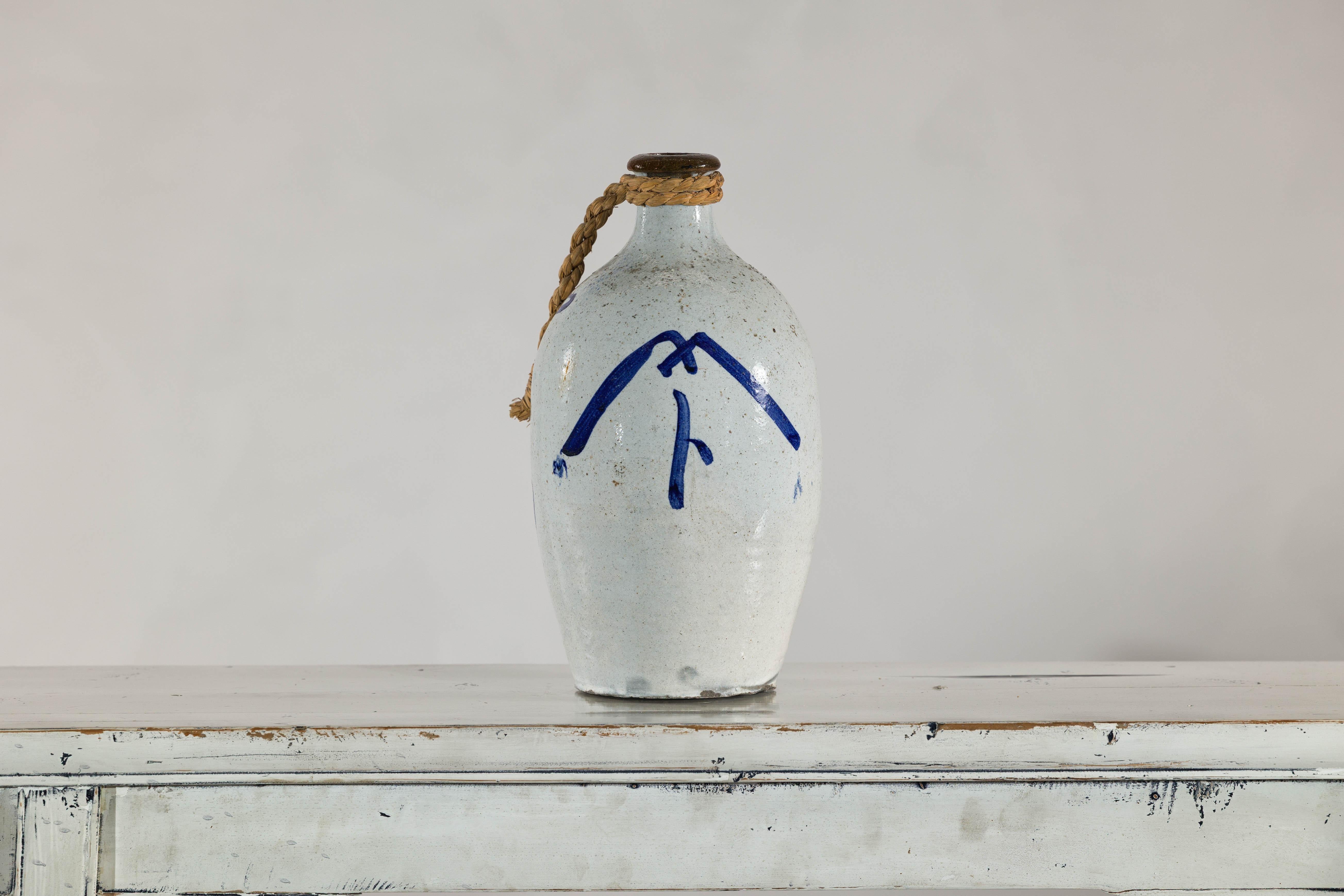 Smaltato Brocca in ceramica bianca e blu con manico in corda intrecciata e calligrafia in vendita
