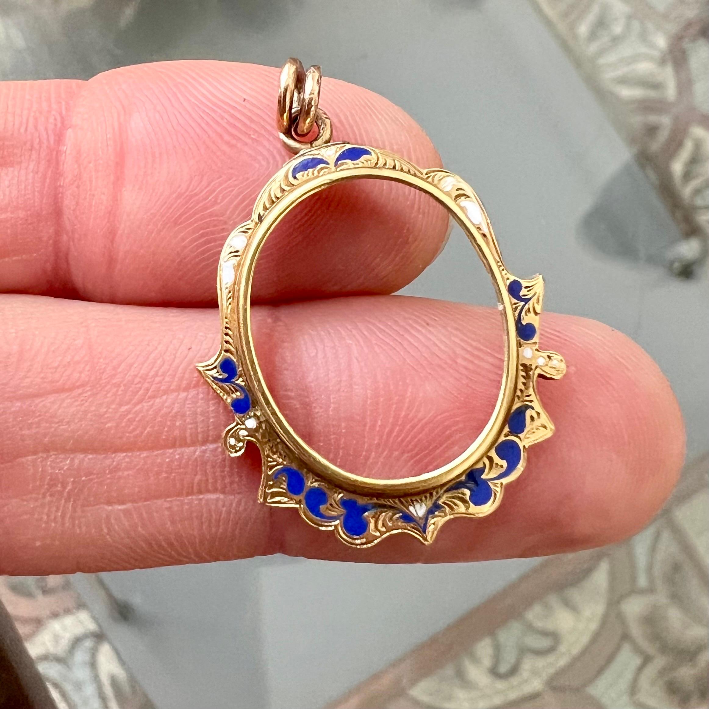 Ce pendentif vintage en or 14 carats présente une belle combinaison d'émaux blancs et bleus dans un délicat motif floral. La pièce maîtresse du pendentif est un cadre ouvert, qui lui donne l'apparence d'un miroir miniature ou d'un cadre photo.
