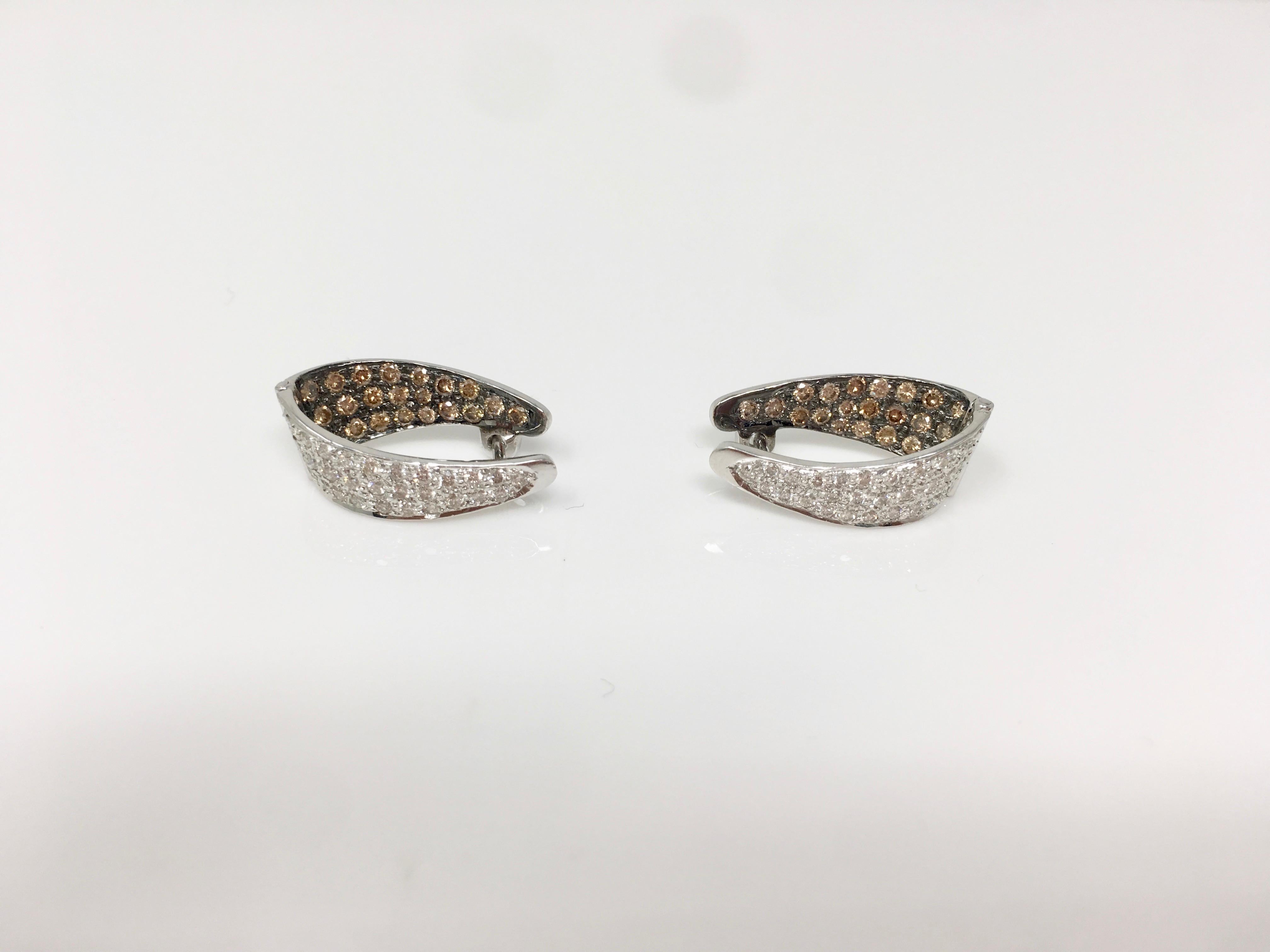 Ces boucles d'oreilles élégantes et tendance, qui présentent un design intérieur étincelant, sont fabriquées à la main en or blanc 18 carats et serties de diamants ronds blancs et de diamants bruns. 
Poids du diamant blanc : 0,56 carat 
Poids du