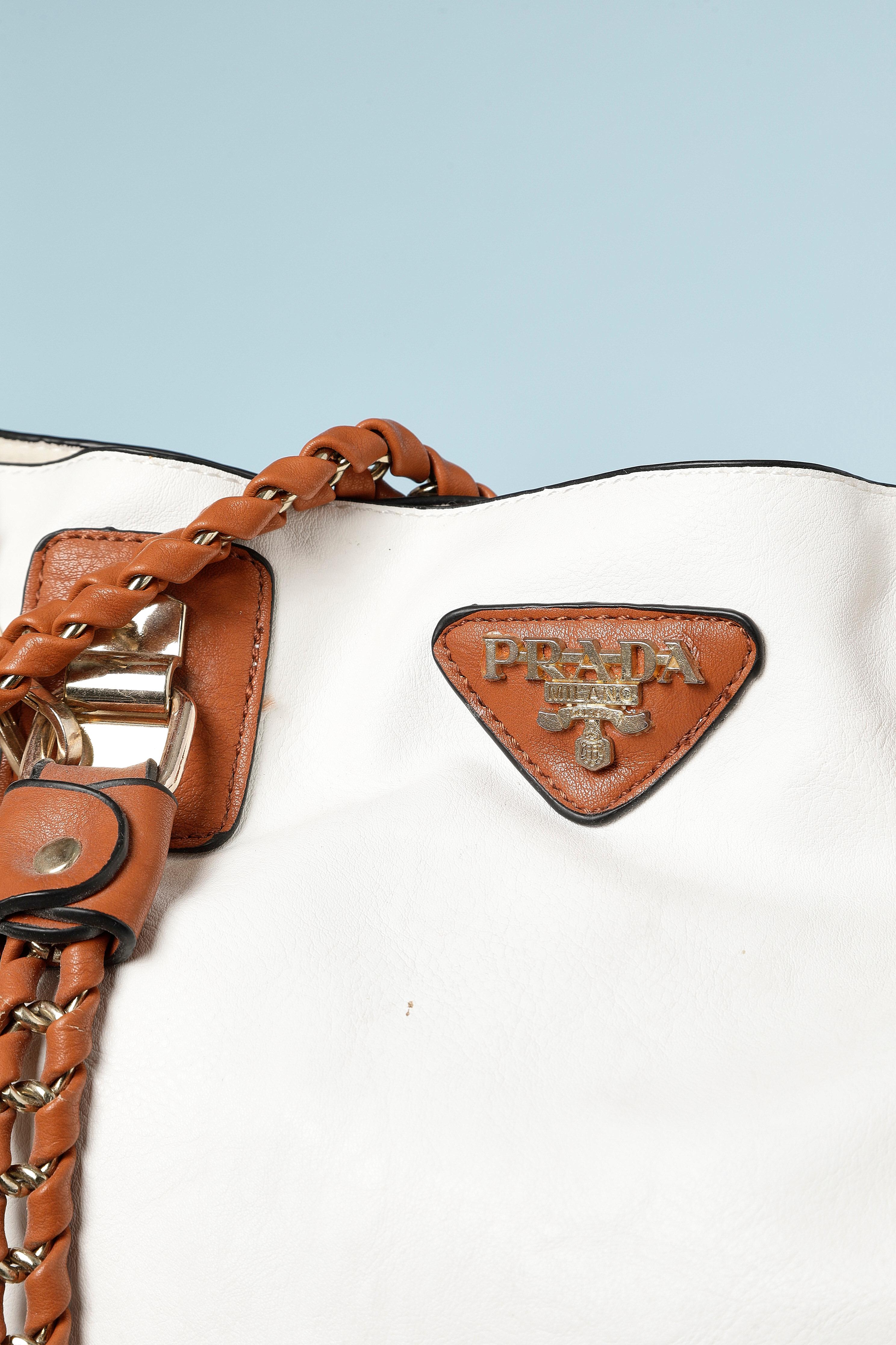 Borsa in pelle bianca e marrone con borsa con zip staccabile in pelle marrone e manico extra della borsa  in pelle bianca (lunghezza= 70 cm). Fodera in cotone avorio. Tracolla in pelle marrone con catena metallica. 
Misure della borsa:
- altezza =
