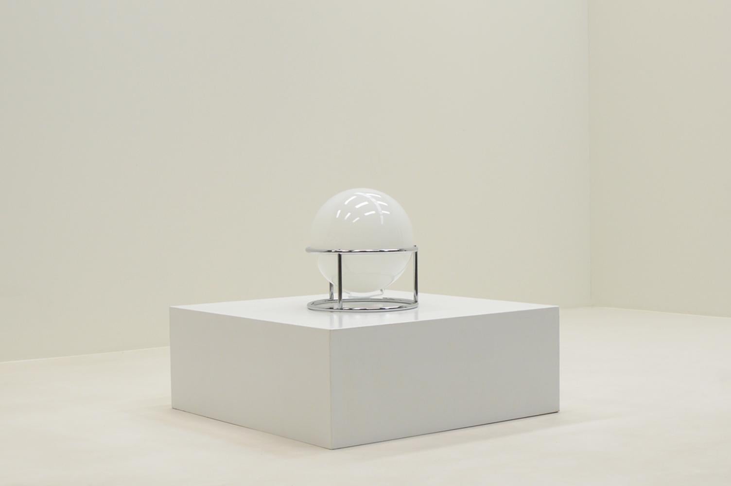 White and chrome globe table lamp, 1970s Italy. White glass globe that holds an E27 bulb and slim round chrome frame. Has been rewired with white cable, switch and EU plug. In very good vintage condition. 

Request a quote for the latest shipping