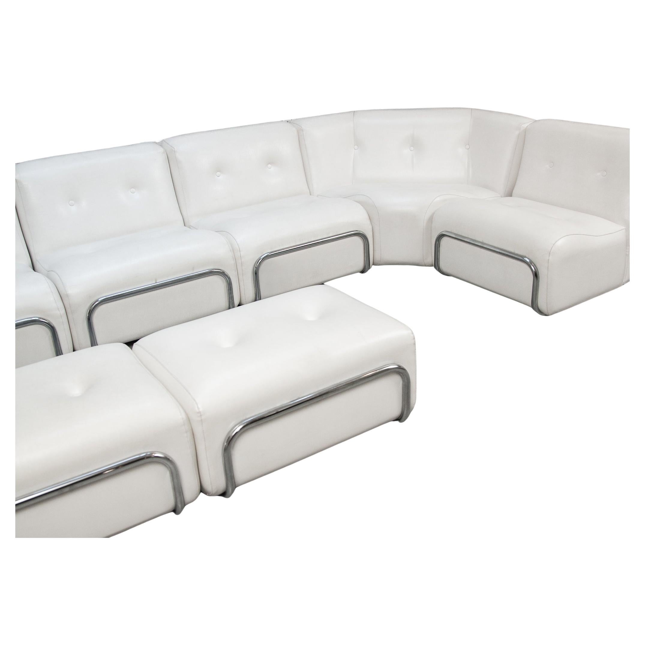 A living-room set of Adriano Piazzesi, Italian 1960's. Beautiful white tufted faux leather lounge chairs, corners and footstools, with chrome-plated tubular steel curved supports in front and back sides, the front and back tubes showcasing the seats