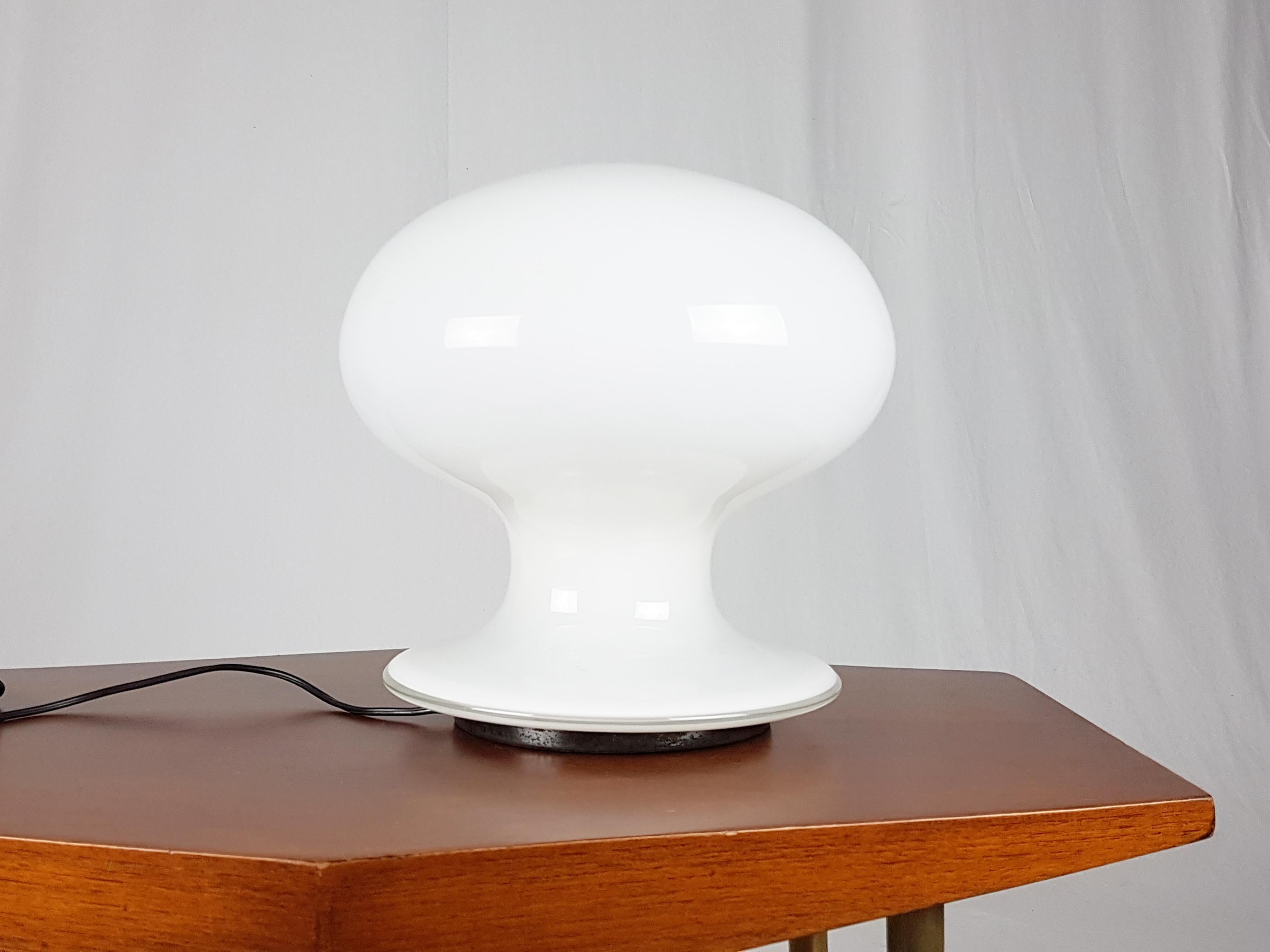 Rare table lamp made from murano glass and burnished metal base. The lamp was produced in the 1960s by the famous Italian glasswork Vistosi.
The body shade is white and features a clear glass edge next to the base.
Original electrical system and