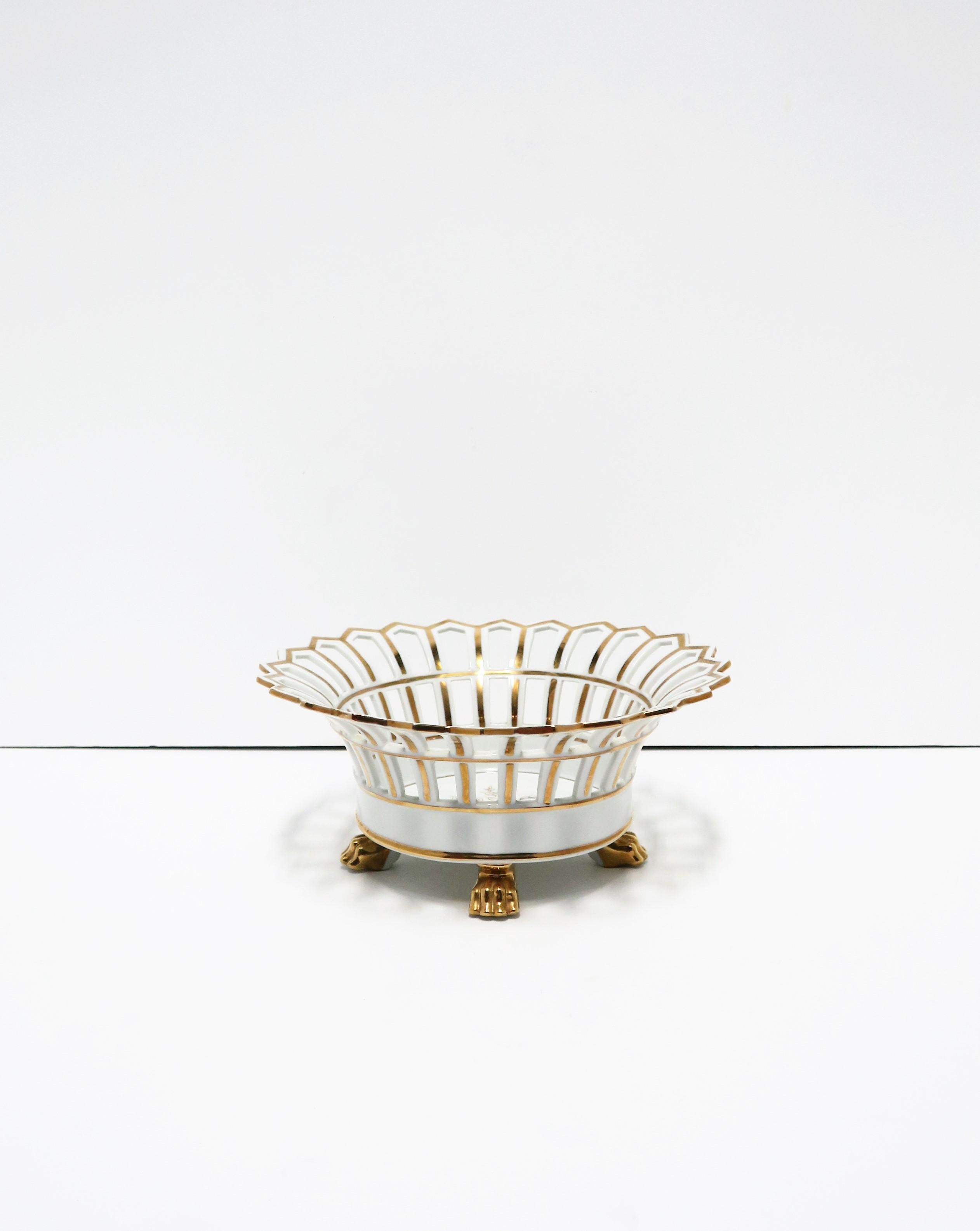 A beautiful French round white and gold pierced Paris Porcelain compote basket centerpiece bowl with lion paw feet in the Empire style, circa 20th century, France. Dimensions: 4.38