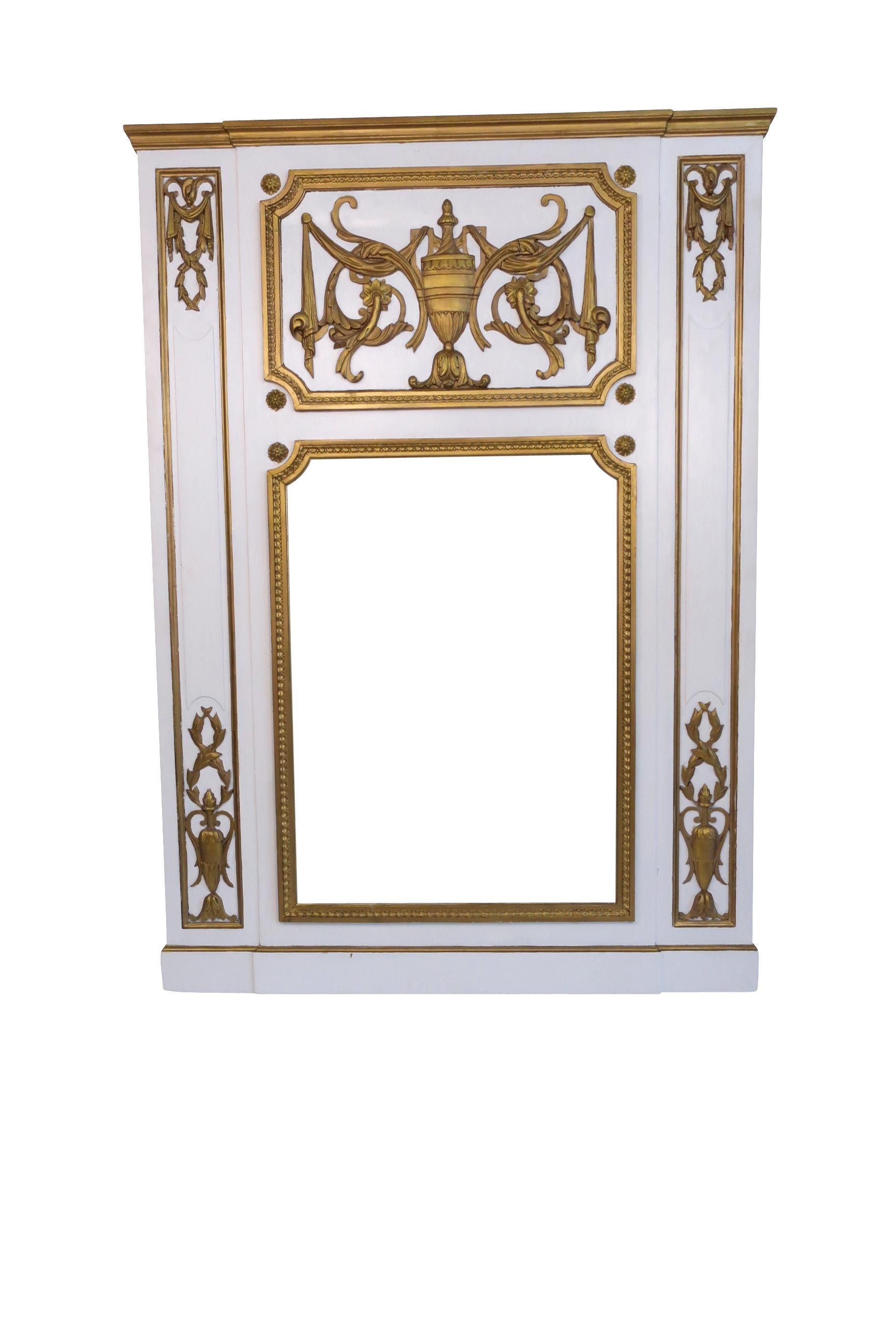 Lovely white and gold painted overmantel mirror with a central stylized urn decoration with garlands and swags draped off the central urn. The top side panels are adorned with stylized swags and laurel wreaths on both corners in true neoclassical
