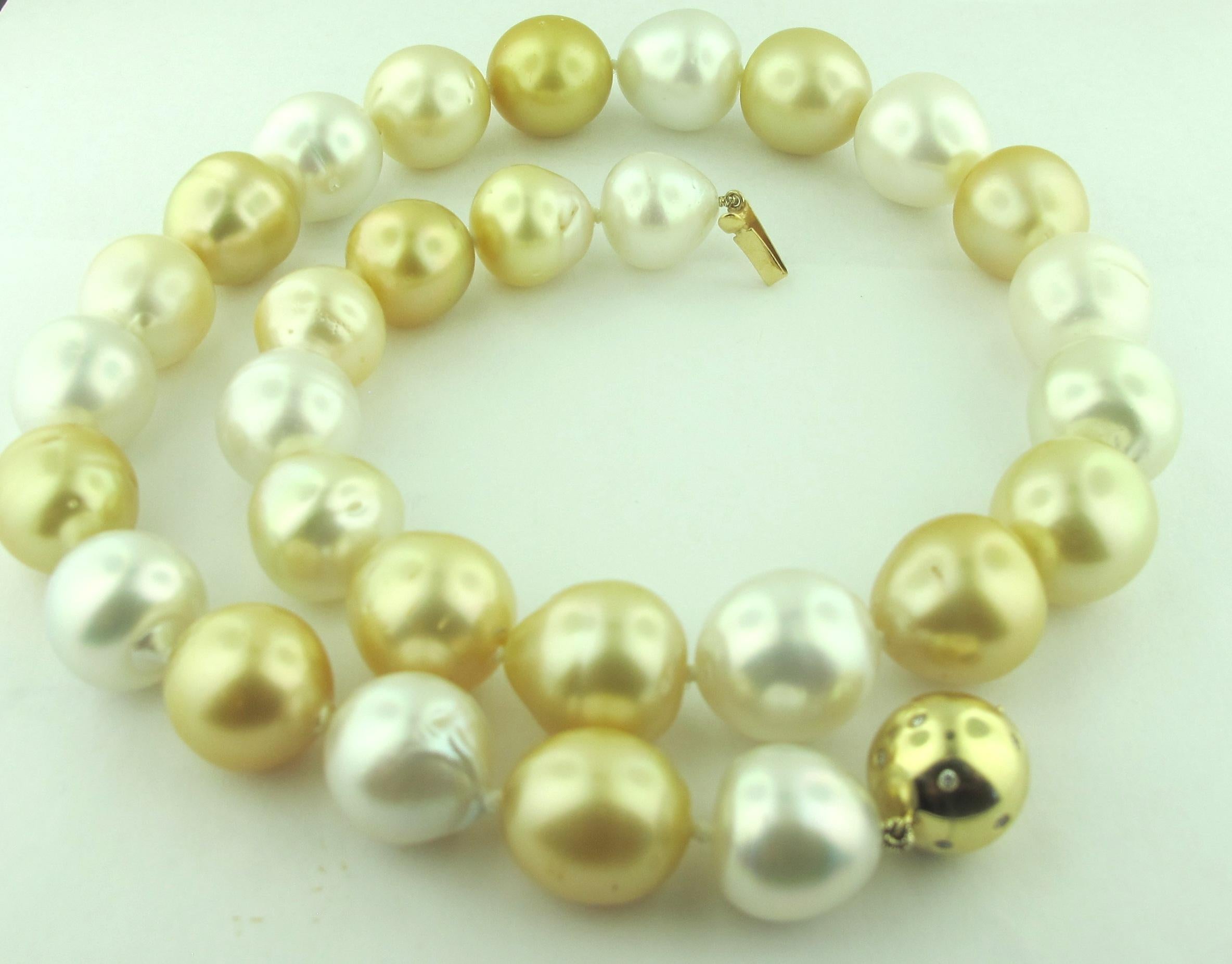 13 to 15 millimeter Golden and White South Sea Pearls with a 14 karat yellow gold ball clasp studded with diamonds.  18