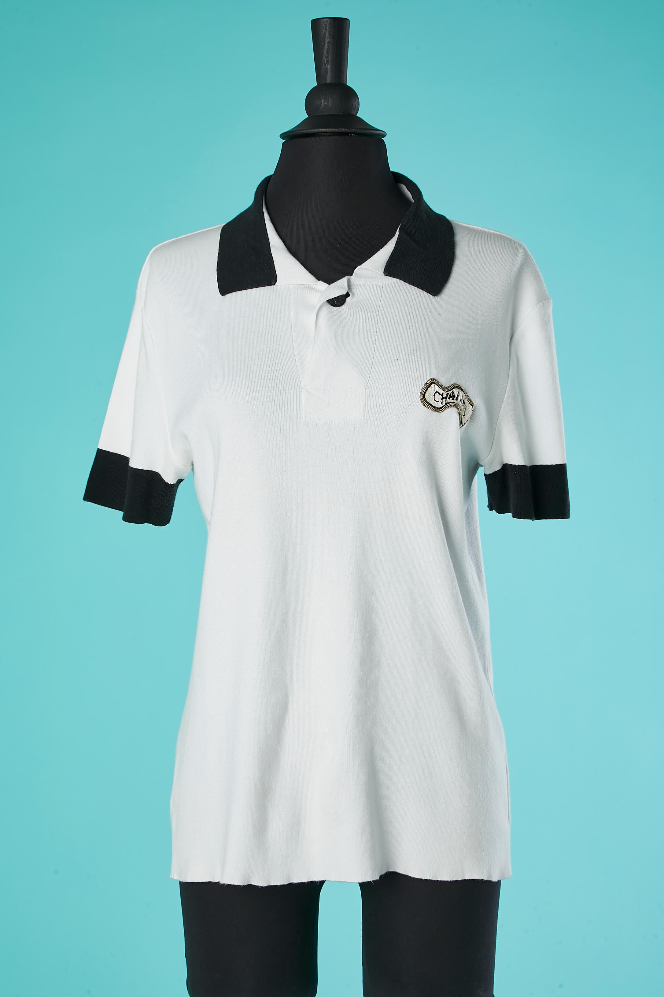 White cotton jersey Polo shirt with navy collar and sleeves with embroideries branded patch on the bust. Branded button on the top middle front. 
SIZE 40 (Fr) L 