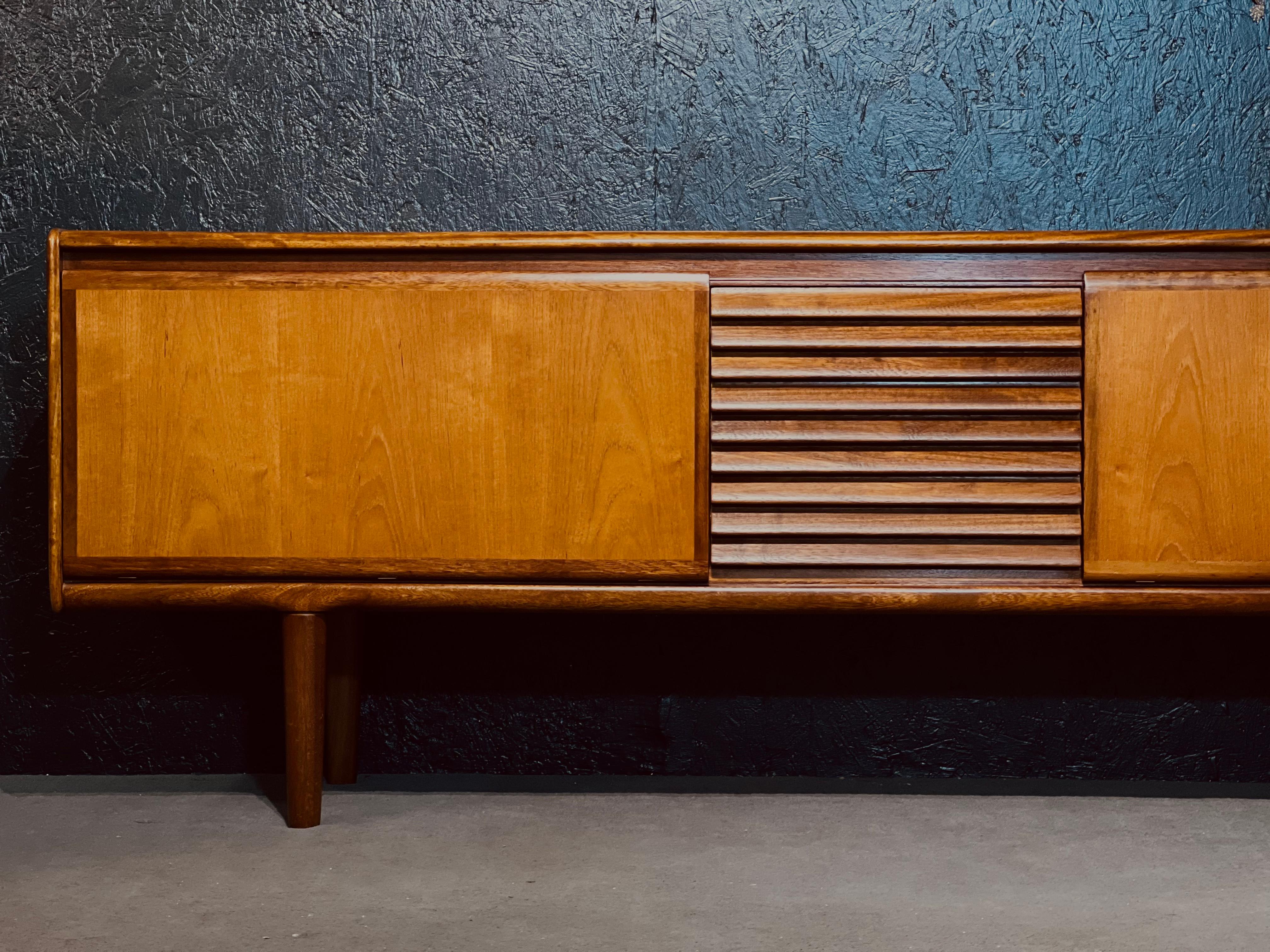 Impressive teak sideboard from the English brand White and Newton. Under the design direction of the talented Arthur Edwards, the firm produced stunning high-end furniture often defined by its clean modern lines and the contrast made by the