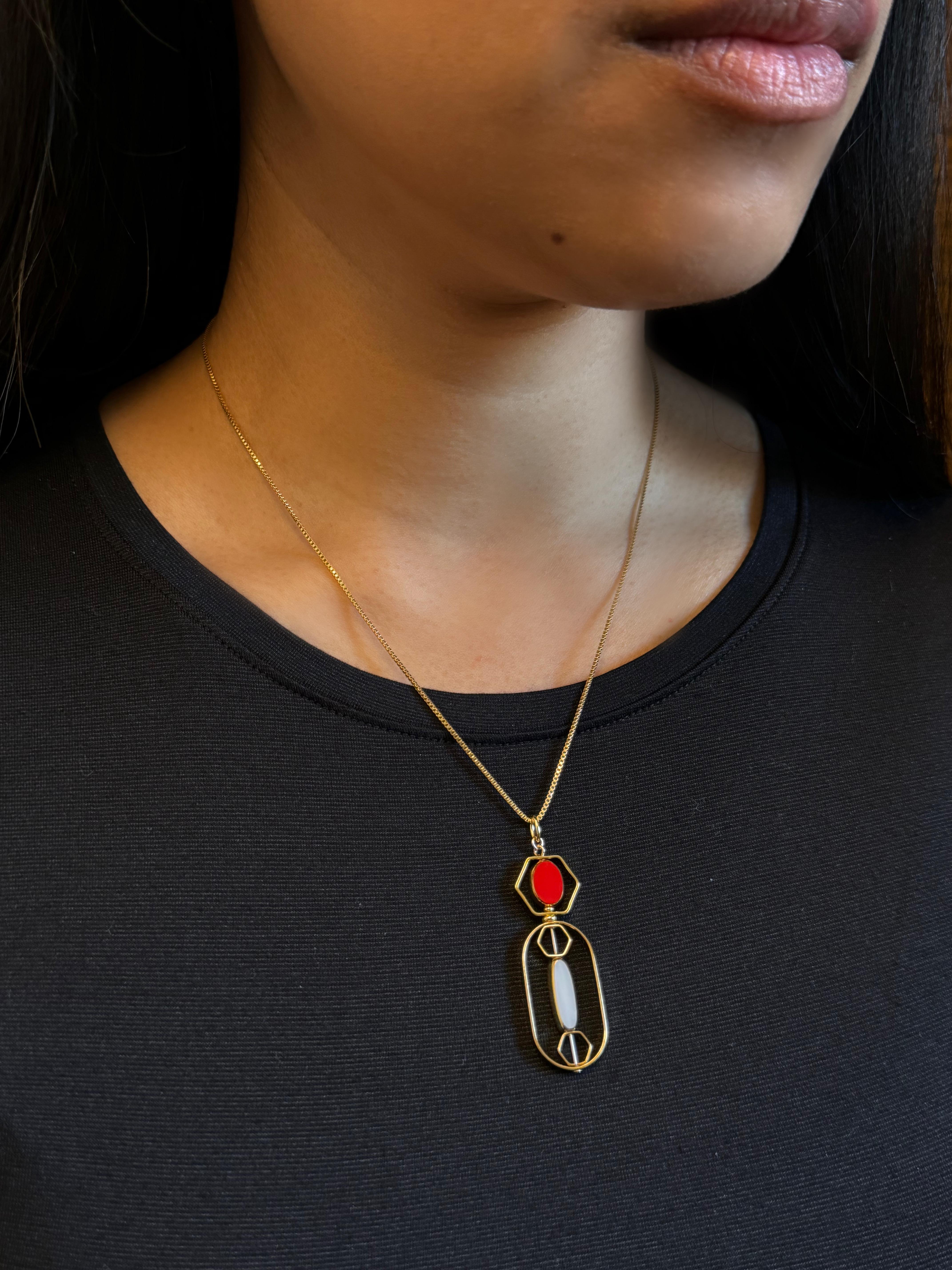 The pendant consists of small red oval and white long oval vintage German glass beads and is finished with an 18-inch gold-filled chain. 

The beads are new old stock vintage German glass beads that are framed with 24K gold. The beads were