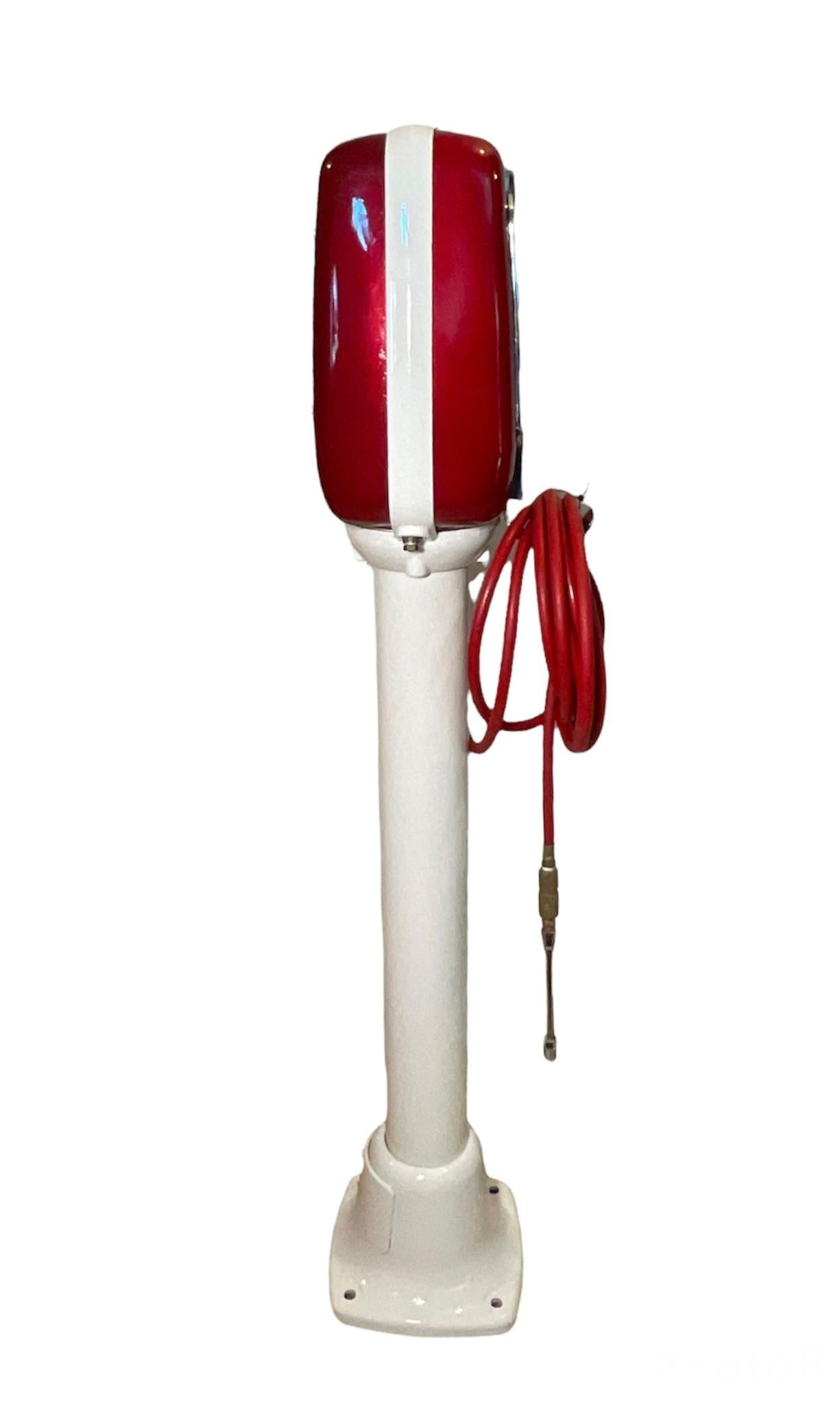 This is an Eco air meter model 98 pedestal mounted. It is painted white and ruby red. It meters the air. It operates by air pressure, not electricity. It is also lighted. This model is no longer being made, but it was made by John Wood Company in